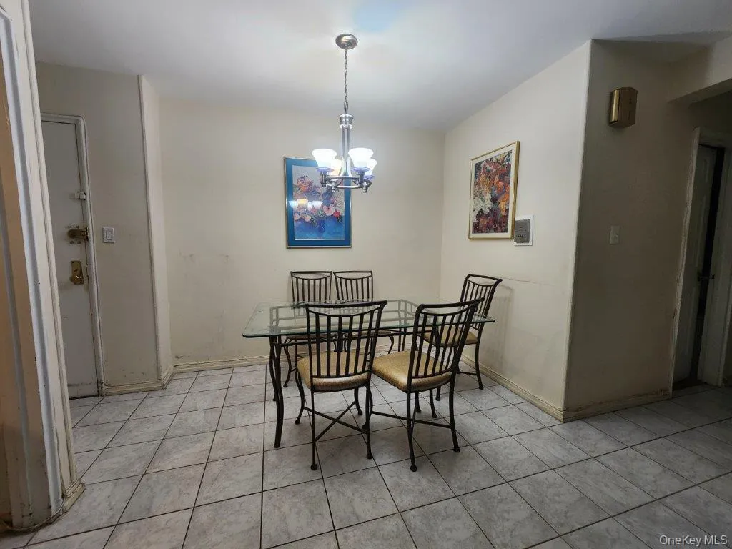 Dining area with light tile patterned floors and a chandelier Dining area with light tile patterned floors and a chandelier