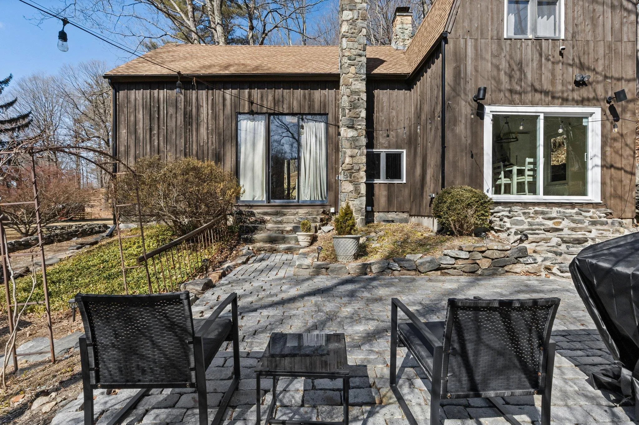 Back of property with a patio area, a chimney, entry steps, and a shingled roof Back of property with a patio area, a chimney, entry steps, and a shingled roof