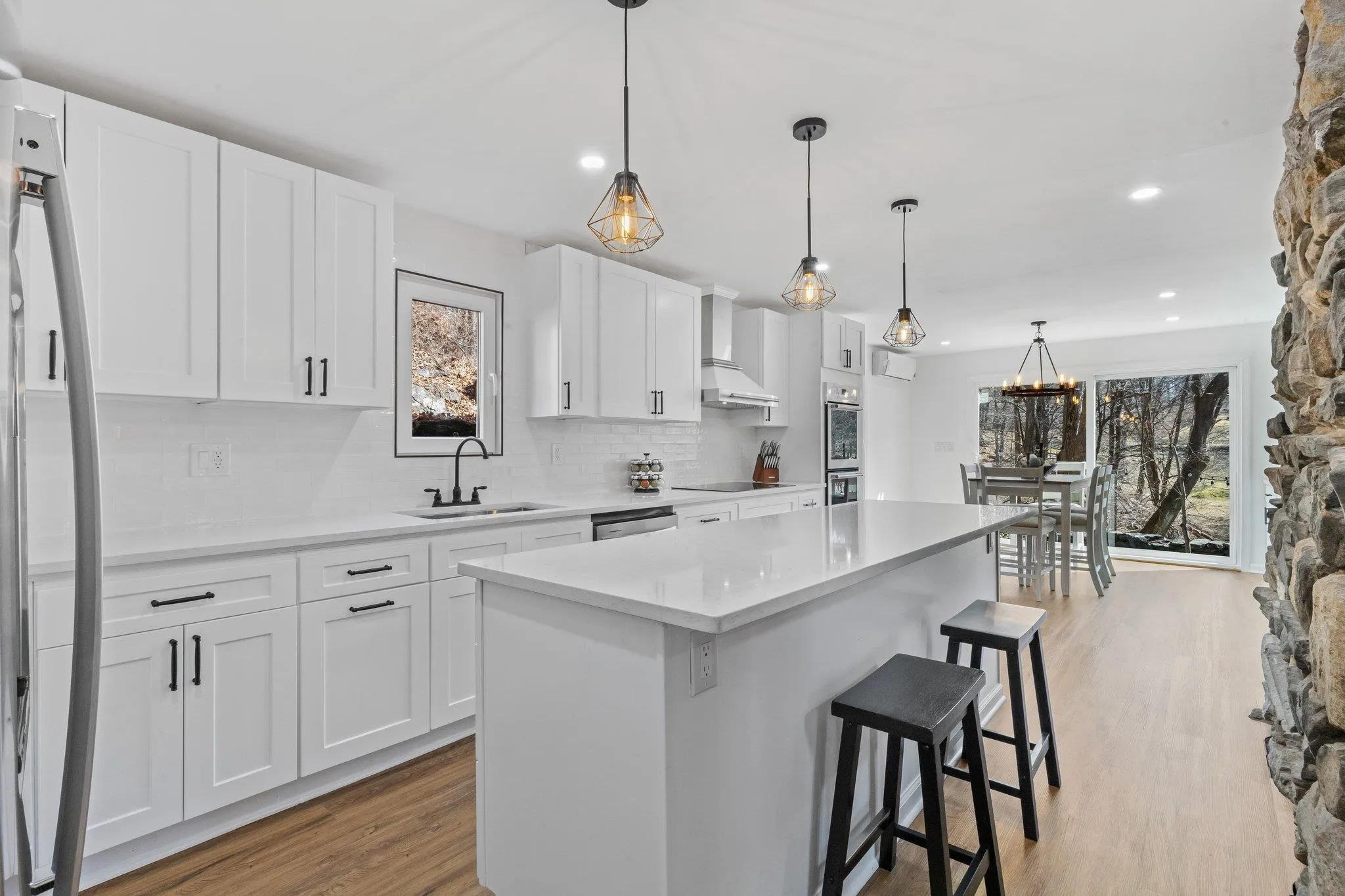 Kitchen with stainless steel appliances, plenty of natural light, light wood-style flooring, tasteful backsplash, and recessed lighting Kitchen with stainless steel appliances, plenty of natural light, light wood-style flooring, tasteful backsplash, and recessed lighting