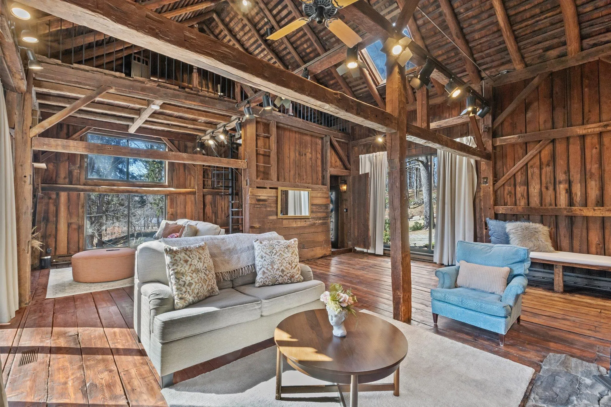 Living room featuring hardwood / wood-style flooring, wooden walls, high vaulted ceiling, and a wooden ceiling with exposed beams Living room featuring hardwood / wood-style flooring, wooden walls, high vaulted ceiling, and a wooden ceiling with exposed beams