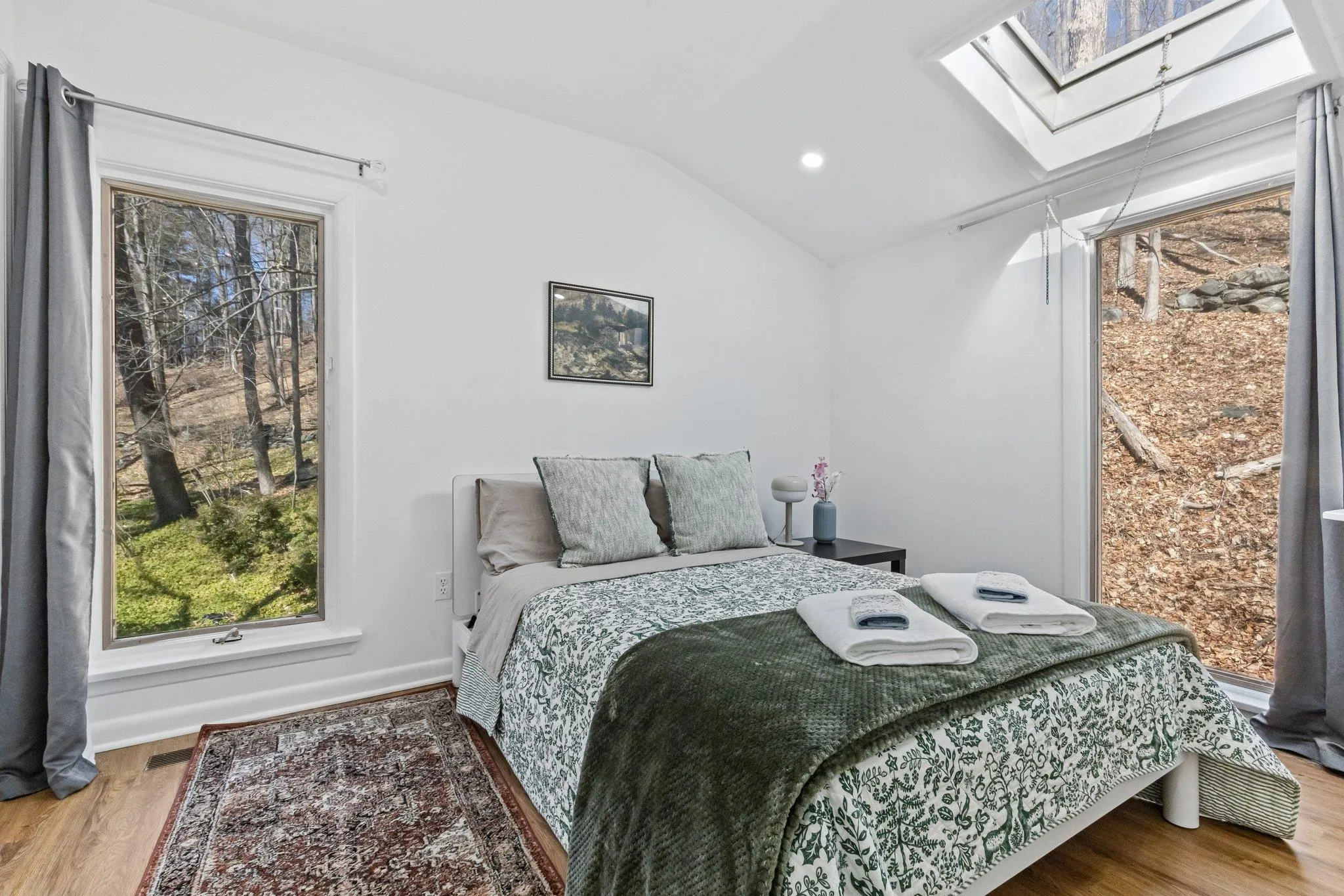 Bedroom featuring a skylight, wood finished floors, vaulted ceiling, and recessed lighting Bedroom featuring a skylight, wood finished floors, vaulted ceiling, and recessed lighting