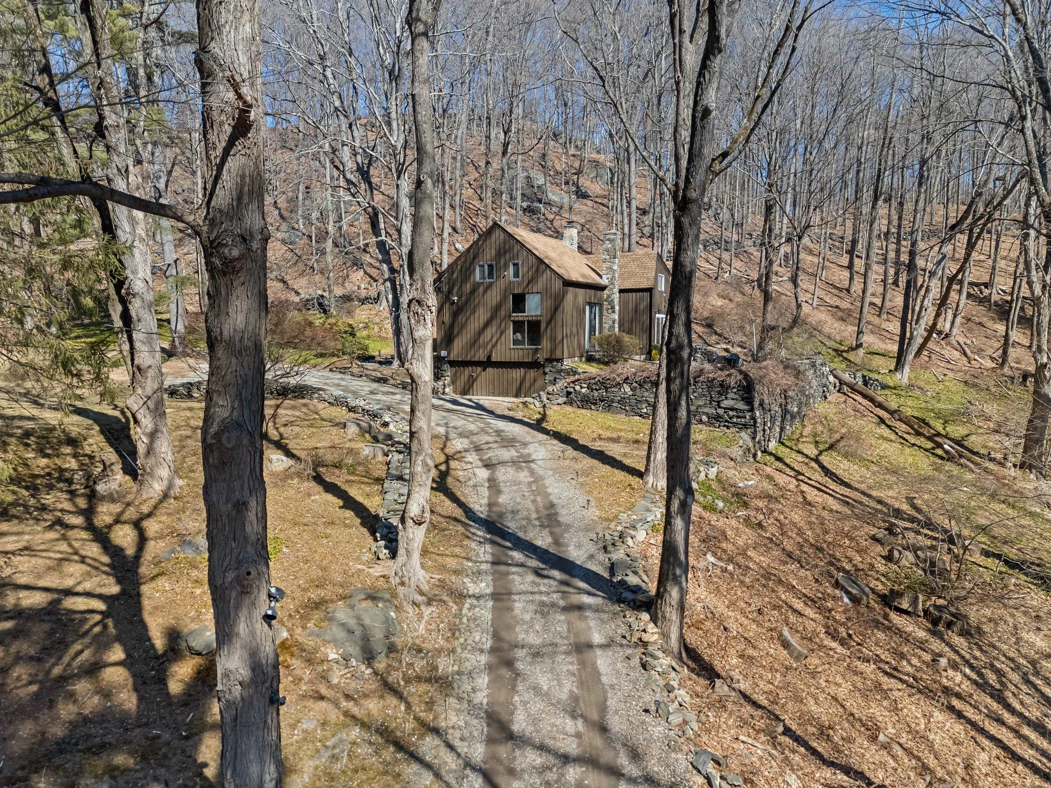 View of front of home featuring a chimney and driveway View of front of home featuring a chimney and driveway
