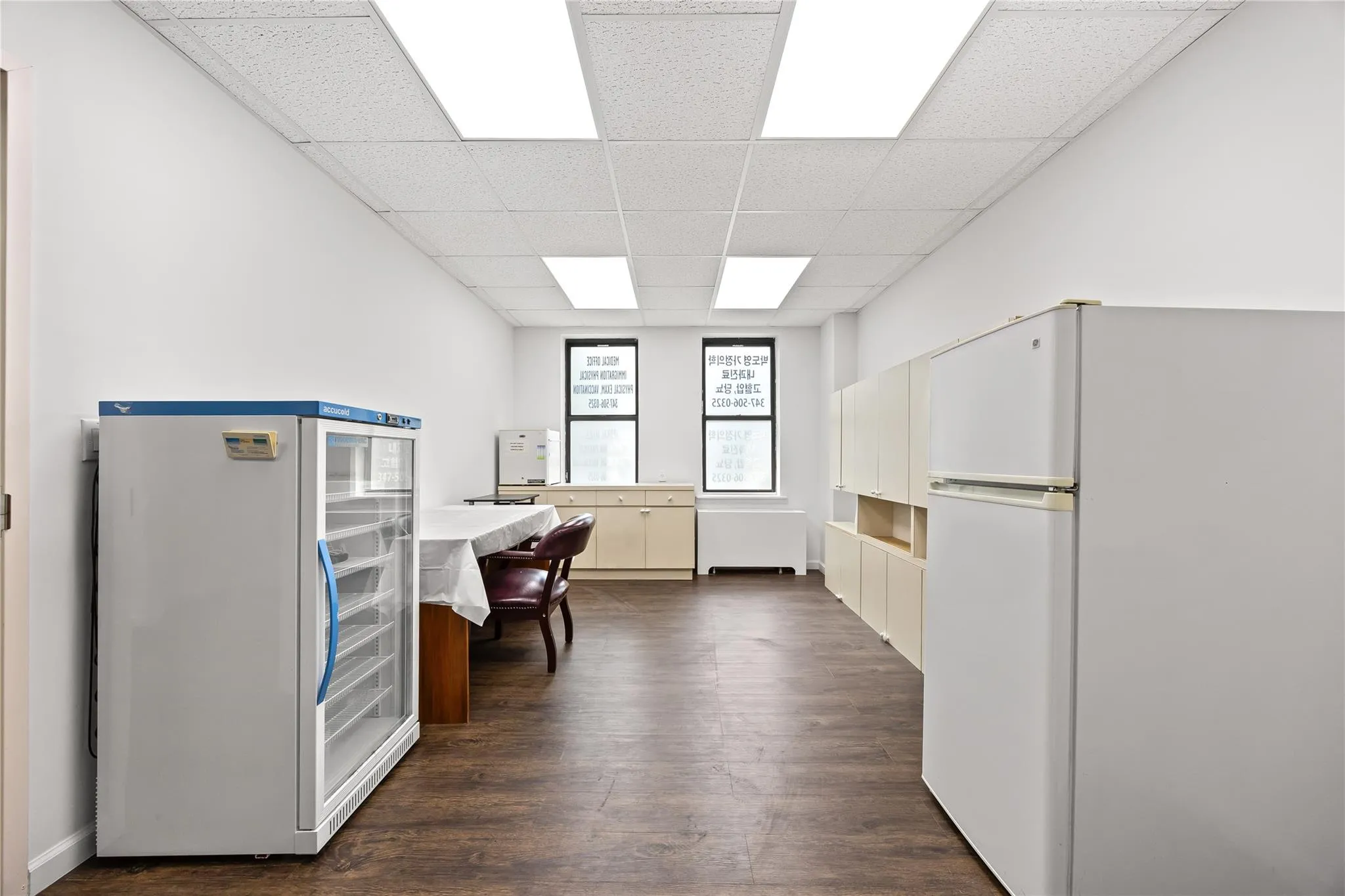 Office area with dark wood-style flooring and a drop ceiling Office area with dark wood-style flooring and a drop ceiling