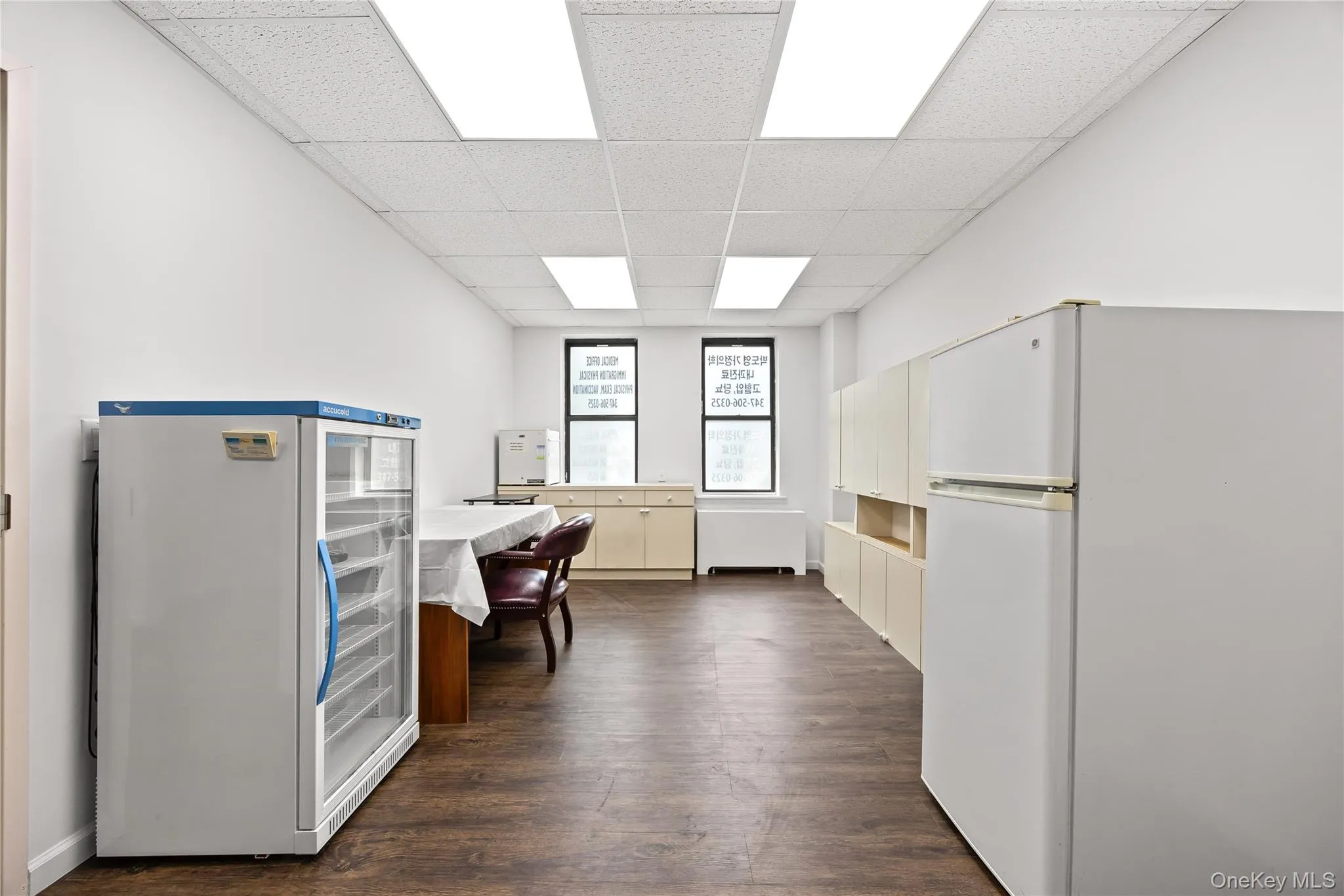 Office area with dark wood-style flooring and a drop ceiling Office area with dark wood-style flooring and a drop ceiling