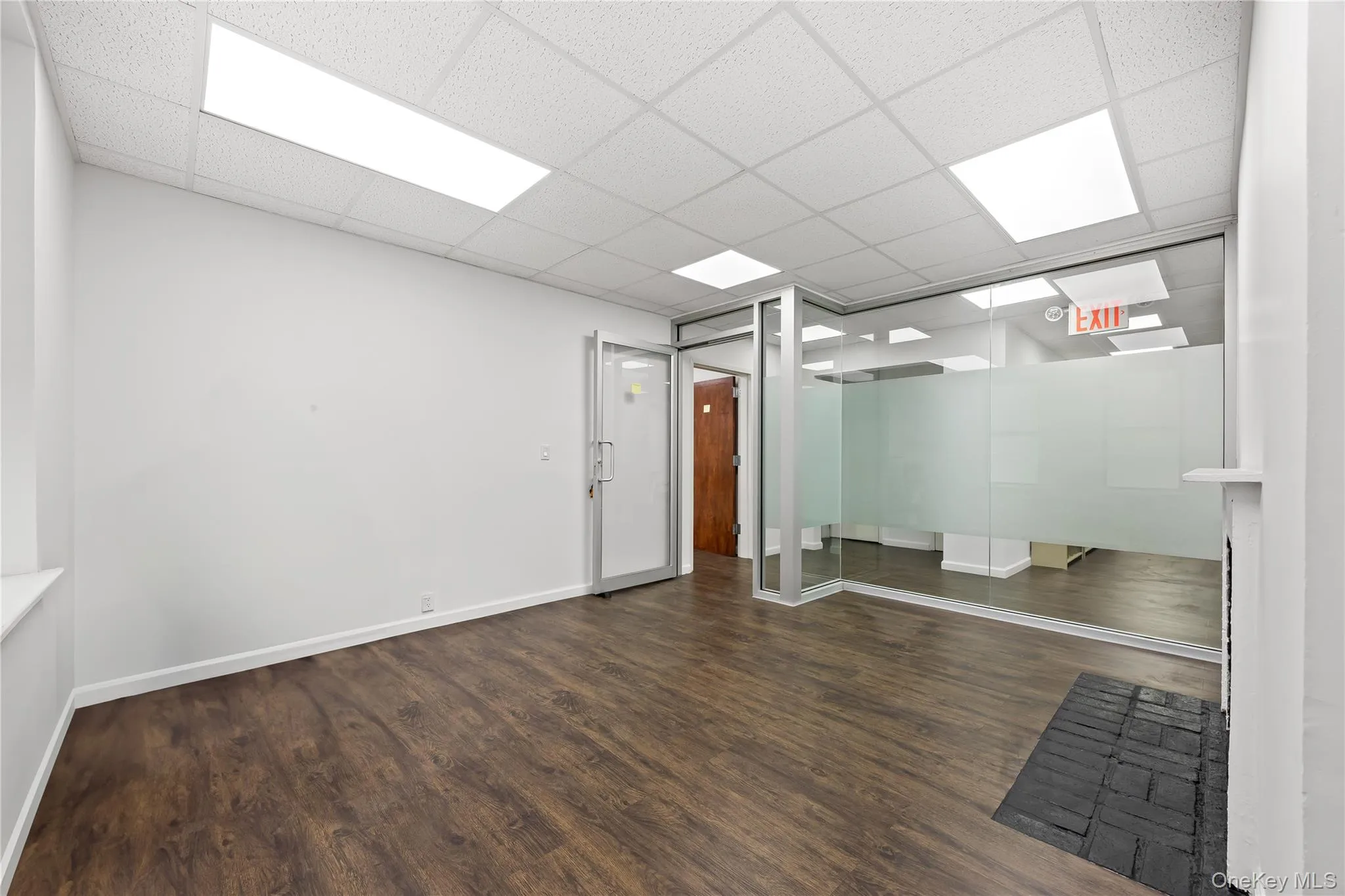 Empty room with wood finished floors and a paneled ceiling Empty room with wood finished floors and a paneled ceiling
