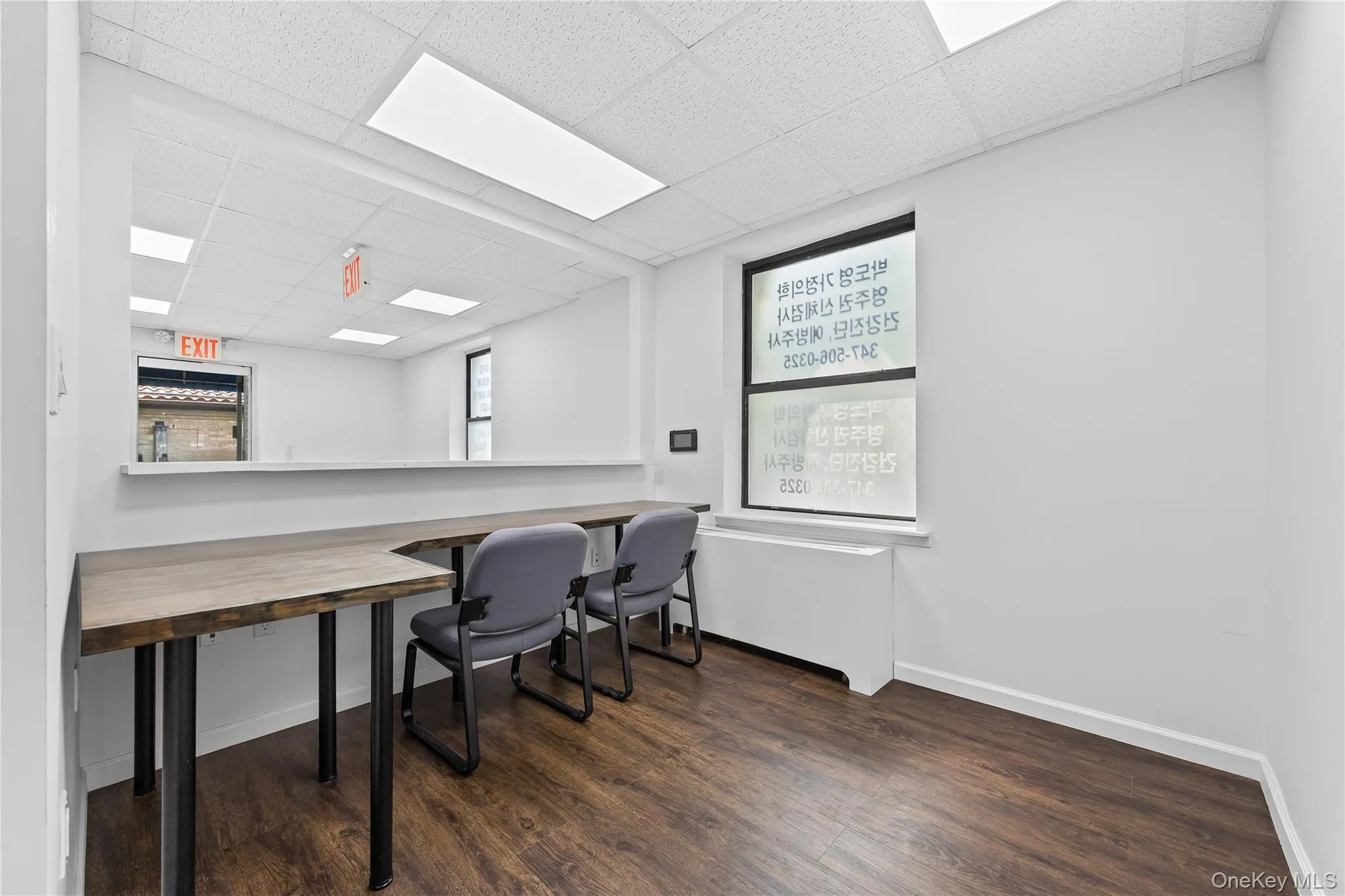 Home office with a paneled ceiling and wood finished floors Home office with a paneled ceiling and wood finished floors