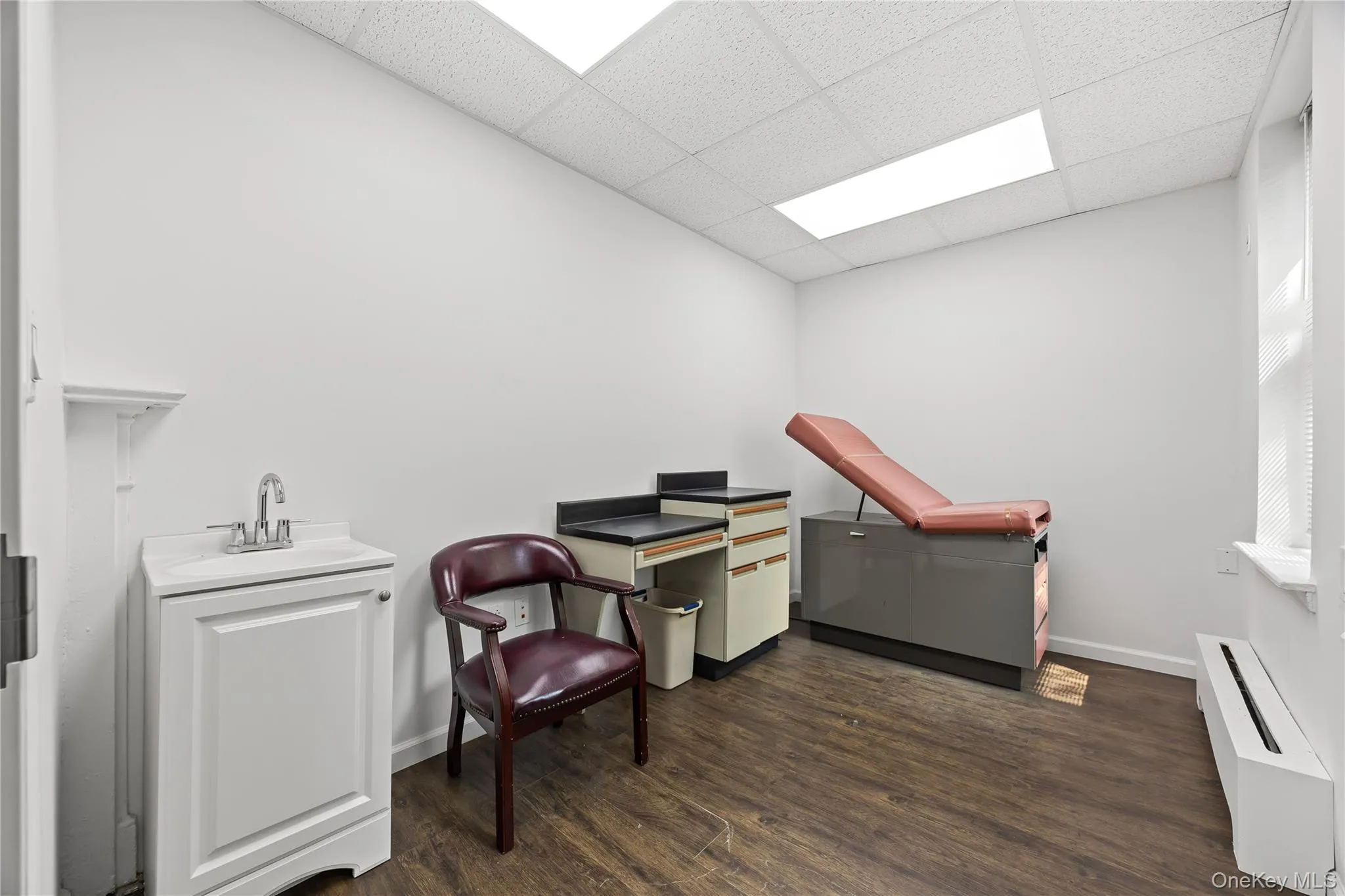 Sitting room with dark wood finished floors and a drop ceiling Sitting room with dark wood finished floors and a drop ceiling