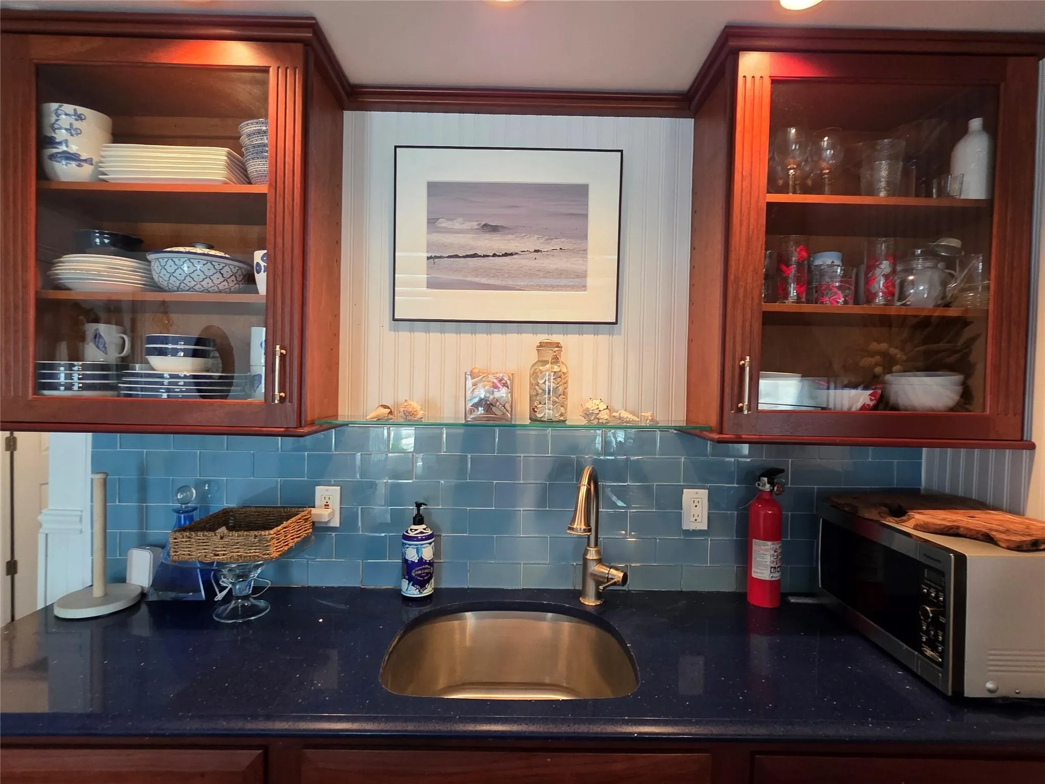 Indoor wet bar with stainless steel microwave and backsplash Indoor wet bar with stainless steel microwave and backsplash