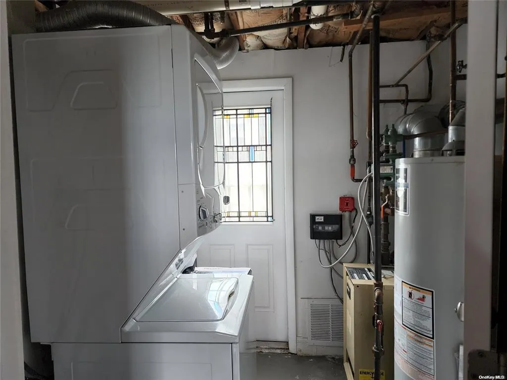 Laundry room featuring gas water heater and estacked washer and dryer Laundry room featuring gas water heater and estacked washer and dryer