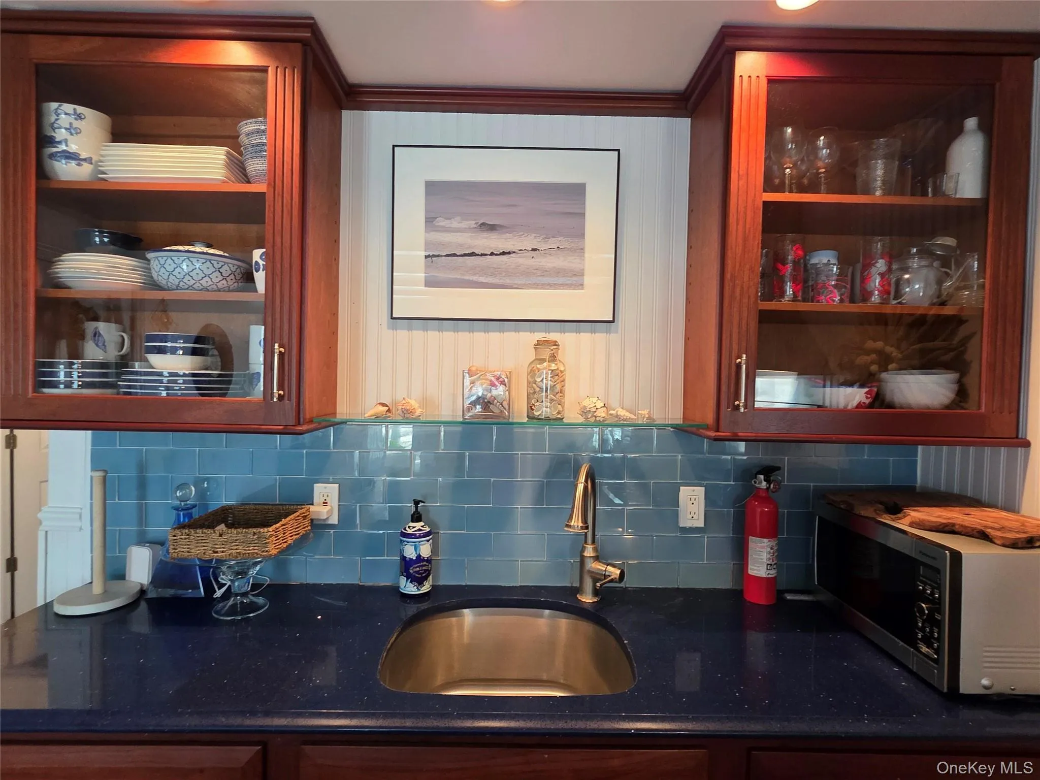 Indoor wet bar with stainless steel microwave and backsplash Indoor wet bar with stainless steel microwave and backsplash