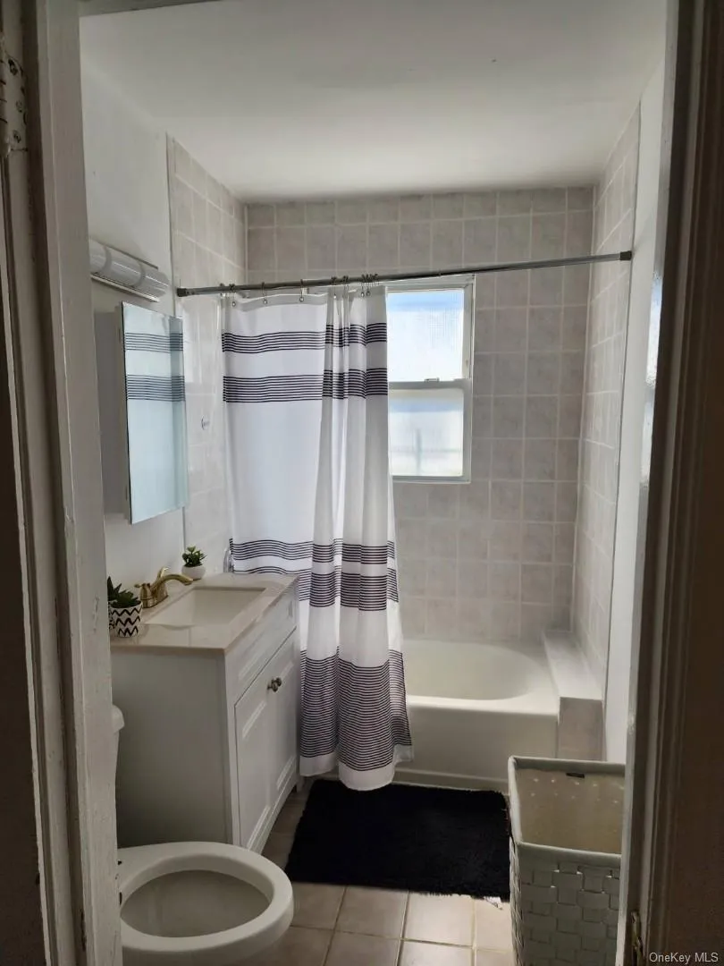 Bathroom with shower / tub combo, tile patterned floors, and vanity Bathroom with shower / tub combo, tile patterned floors, and vanity