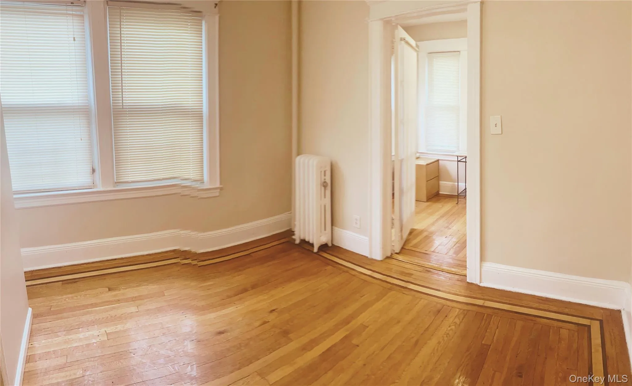 Spare room with radiator and light wood-style floors Spare room with radiator and light wood-style floors