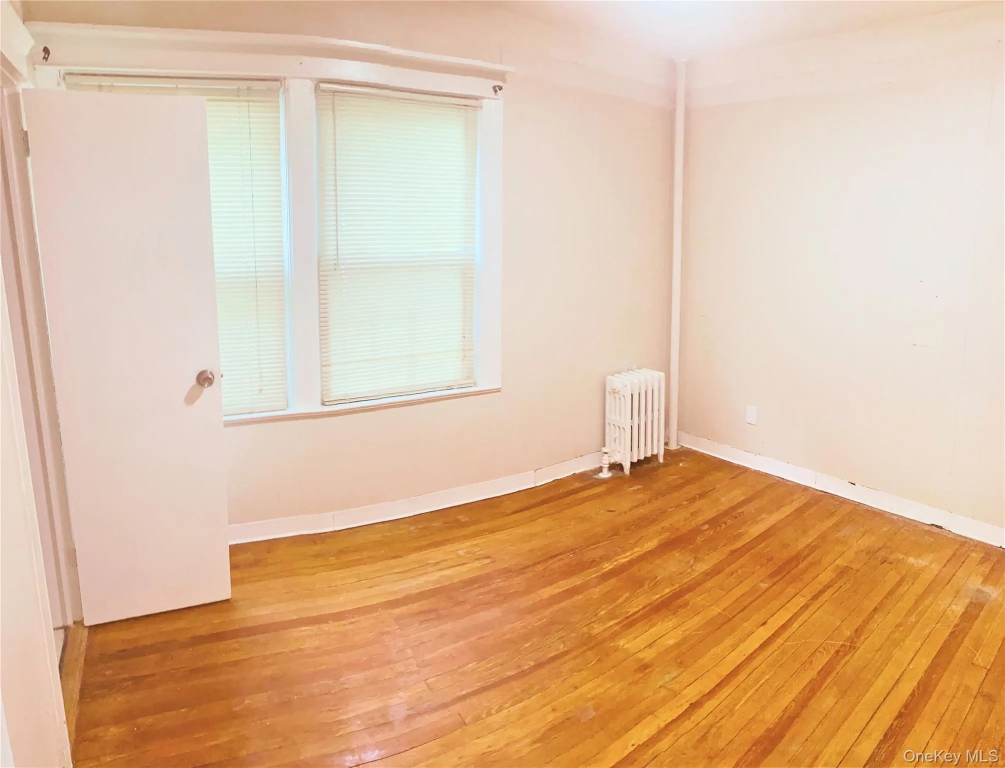 Spare room with radiator and hardwood / wood-style flooring Spare room with radiator and hardwood / wood-style flooring