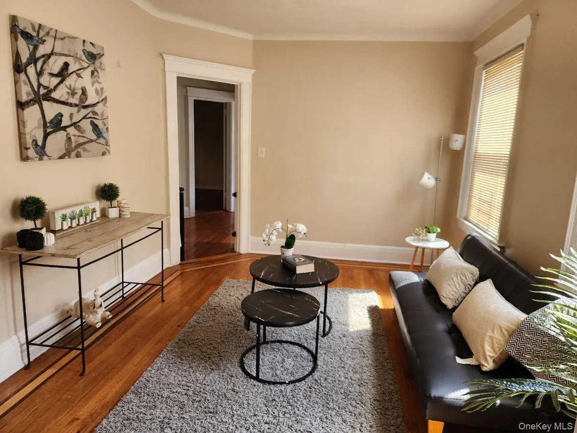 Living room with wood finished floors and ornamental molding Living room with wood finished floors and ornamental molding