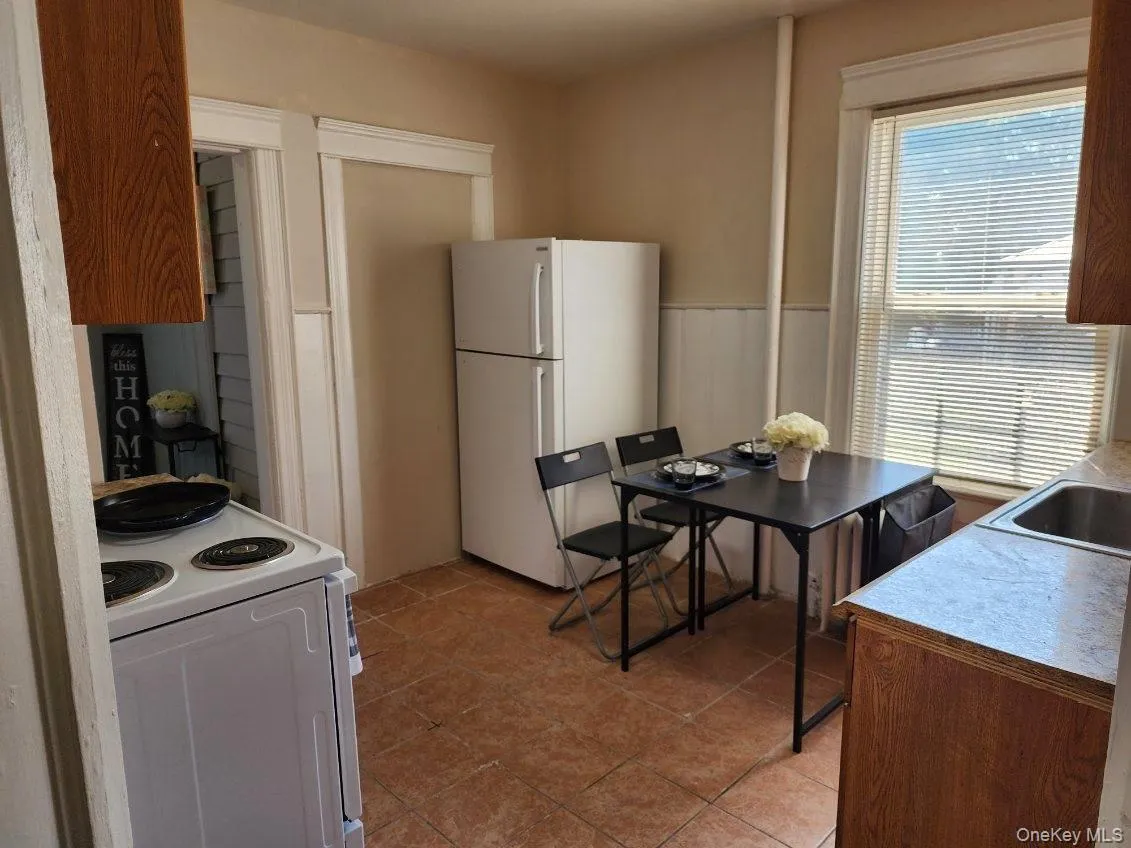 Kitchen with white appliances, light countertops, and light tile patterned floors Kitchen with white appliances, light countertops, and light tile patterned floors