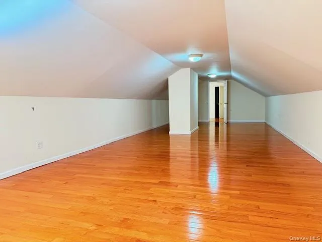Bonus room featuring light wood-style flooring and lofted ceiling Bonus room featuring light wood-style flooring and lofted ceiling