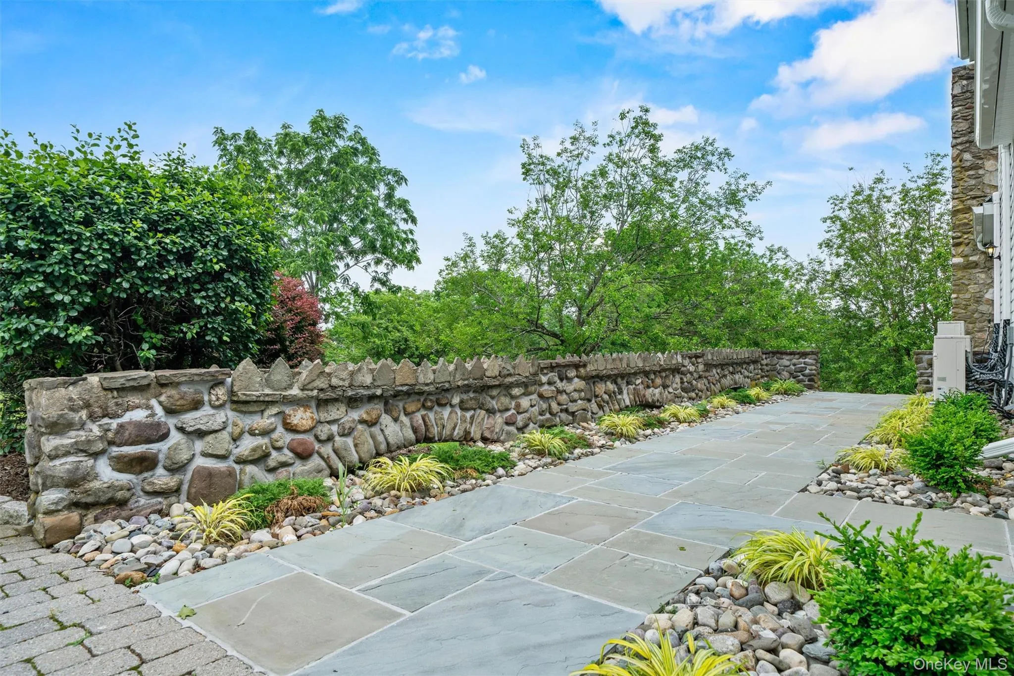 New blue stone patio off of front porch, new planting beds surrounding patio, repointed original stone wall New blue stone patio off of front porch, new planting beds surrounding patio, repointed original stone wall