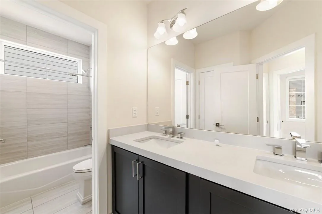 Full hall bath with two sinks, linen closet, door to the separate tub/shower Full hall bath with two sinks, linen closet, door to the separate tub/shower