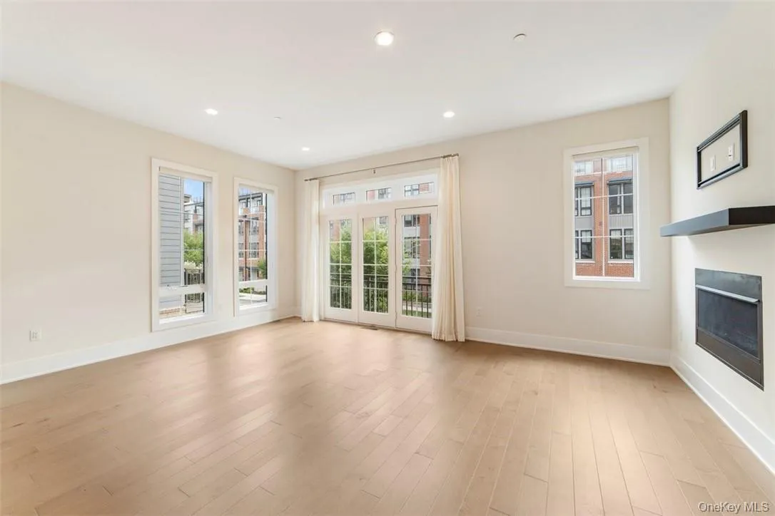 Expansive living room is bright and airy, with gas fireplace for cozy winter nights, door to Juliette balcony, floor-to-ceiling windows, recessed lighting Expansive living room is bright and airy, with gas fireplace for cozy winter nights, door to Juliette balcony, floor-to-ceiling windows, recessed lighting