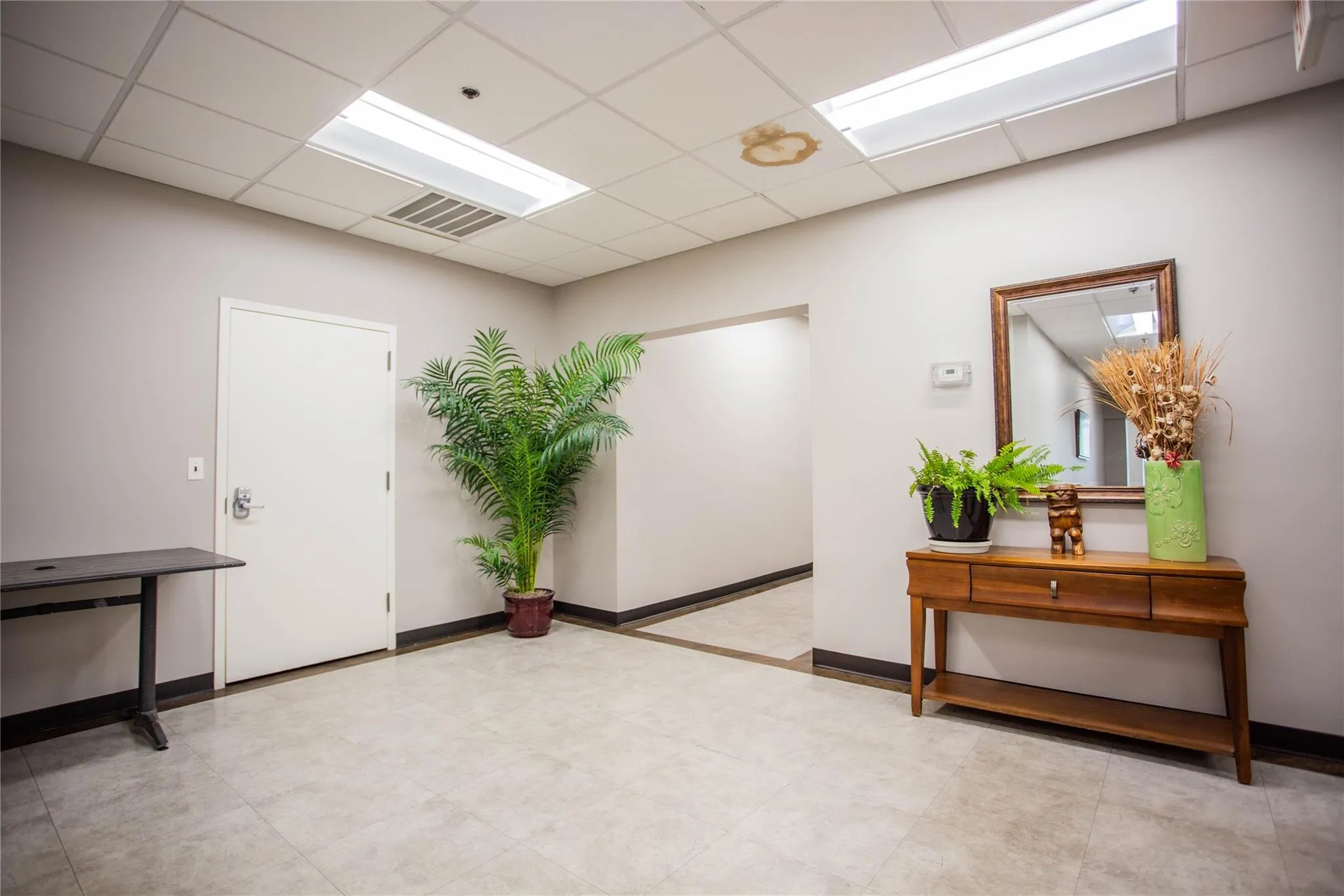 Hallway with a drop ceiling and baseboards Hallway with a drop ceiling and baseboards