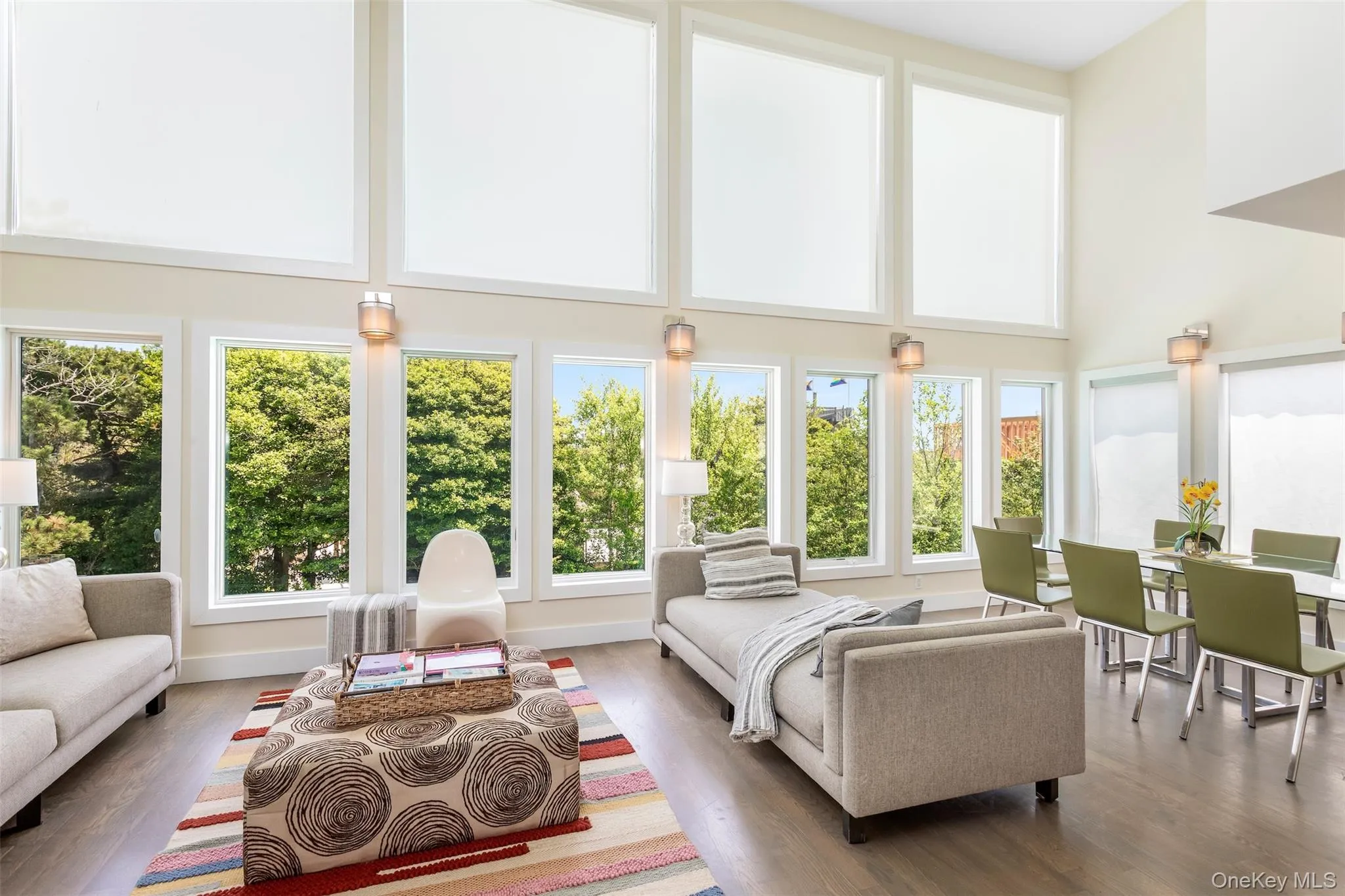 Living area with healthy amount of natural light, a high ceiling, and wood finished floors Living area with healthy amount of natural light, a high ceiling, and wood finished floors