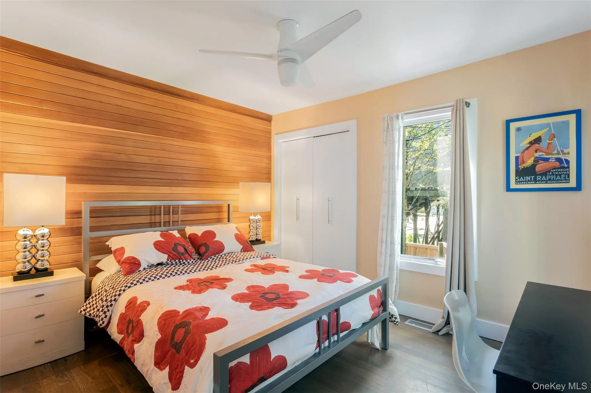 Bedroom featuring wood walls, dark wood-type flooring, a closet, and ceiling fan Bedroom featuring wood walls, dark wood-type flooring, a closet, and ceiling fan