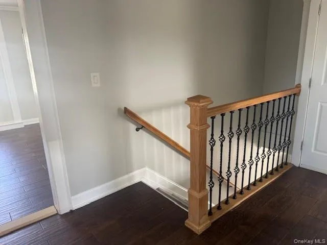 Stairs featuring wood finished floors and baseboards Stairs featuring wood finished floors and baseboards