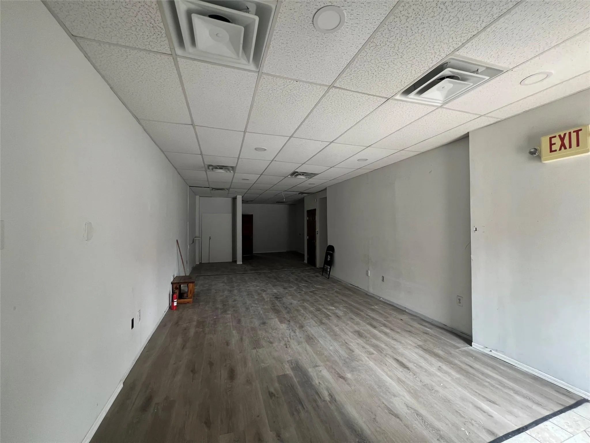 Finished below grade area featuring wood finished floors and a paneled ceiling Finished below grade area featuring wood finished floors and a paneled ceiling
