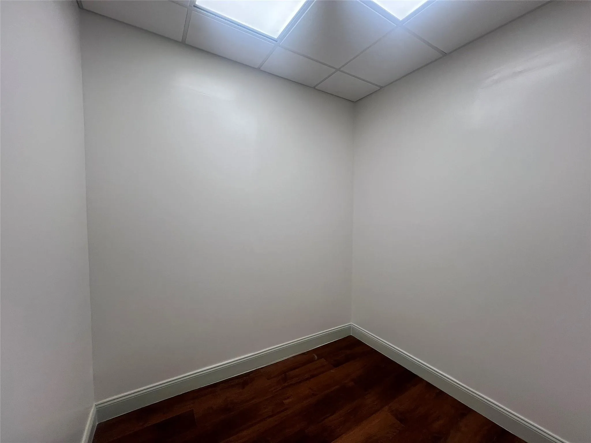 Unfurnished room featuring dark wood-style floors and a paneled ceiling Unfurnished room featuring dark wood-style floors and a paneled ceiling