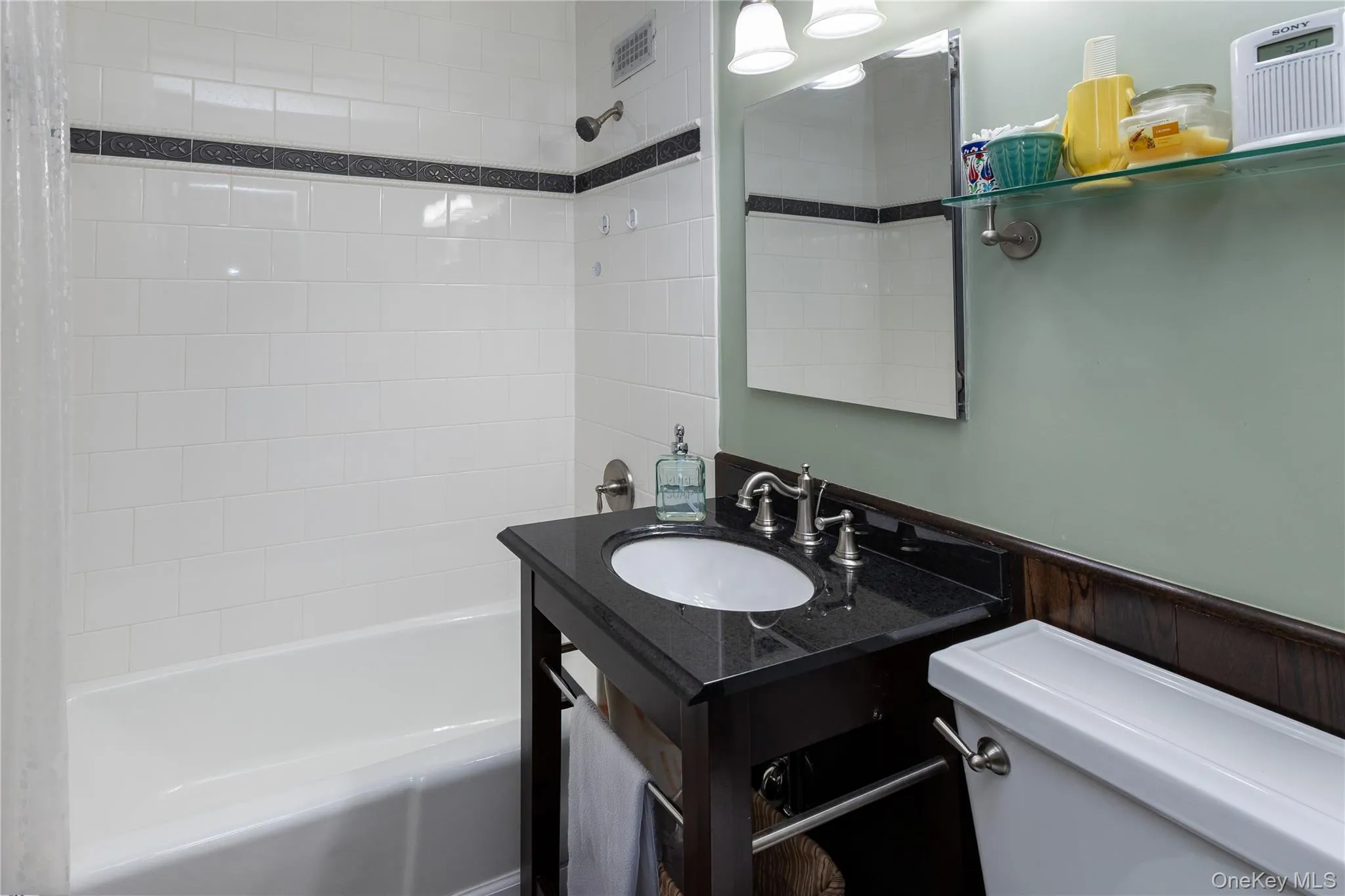 Bathroom with tub / shower combination, a wainscoted wall, and vanity Bathroom with tub / shower combination, a wainscoted wall, and vanity