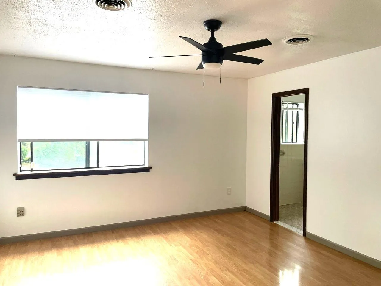 Unfurnished room featuring light wood-type flooring, ceiling fan, and a textured ceiling Unfurnished room featuring light wood-type flooring, ceiling fan, and a textured ceiling