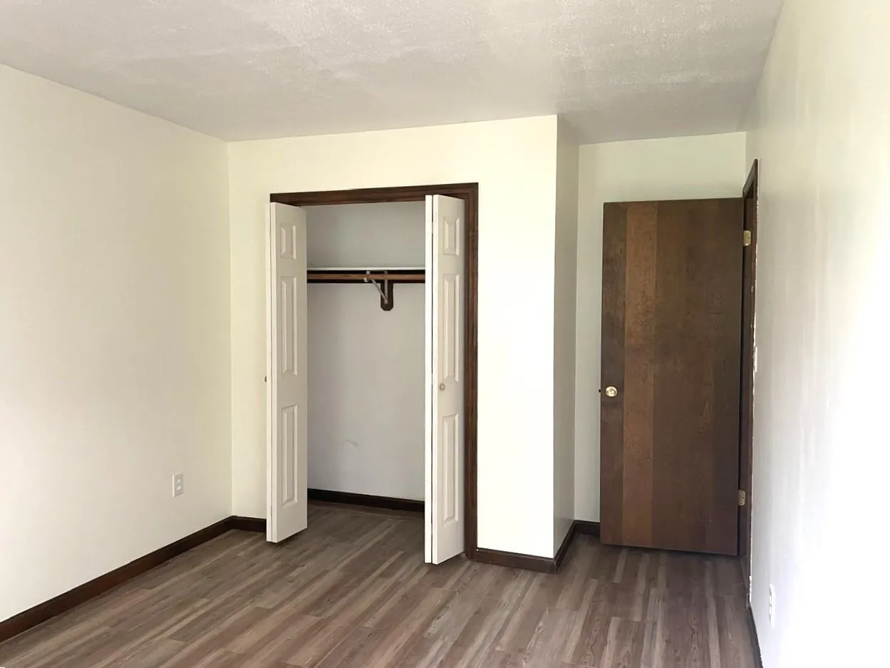 Unfurnished bedroom featuring wood finished floors and a closet Unfurnished bedroom featuring wood finished floors and a closet
