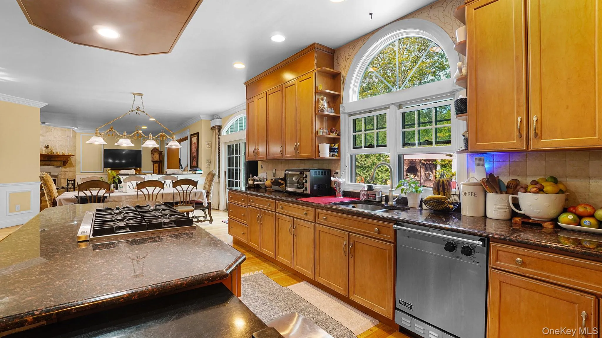 Kitchen featuring dishwasher, open shelves, gas stovetop, brown cabinets, and open floor plan Kitchen featuring dishwasher, open shelves, gas stovetop, brown cabinets, and open floor plan