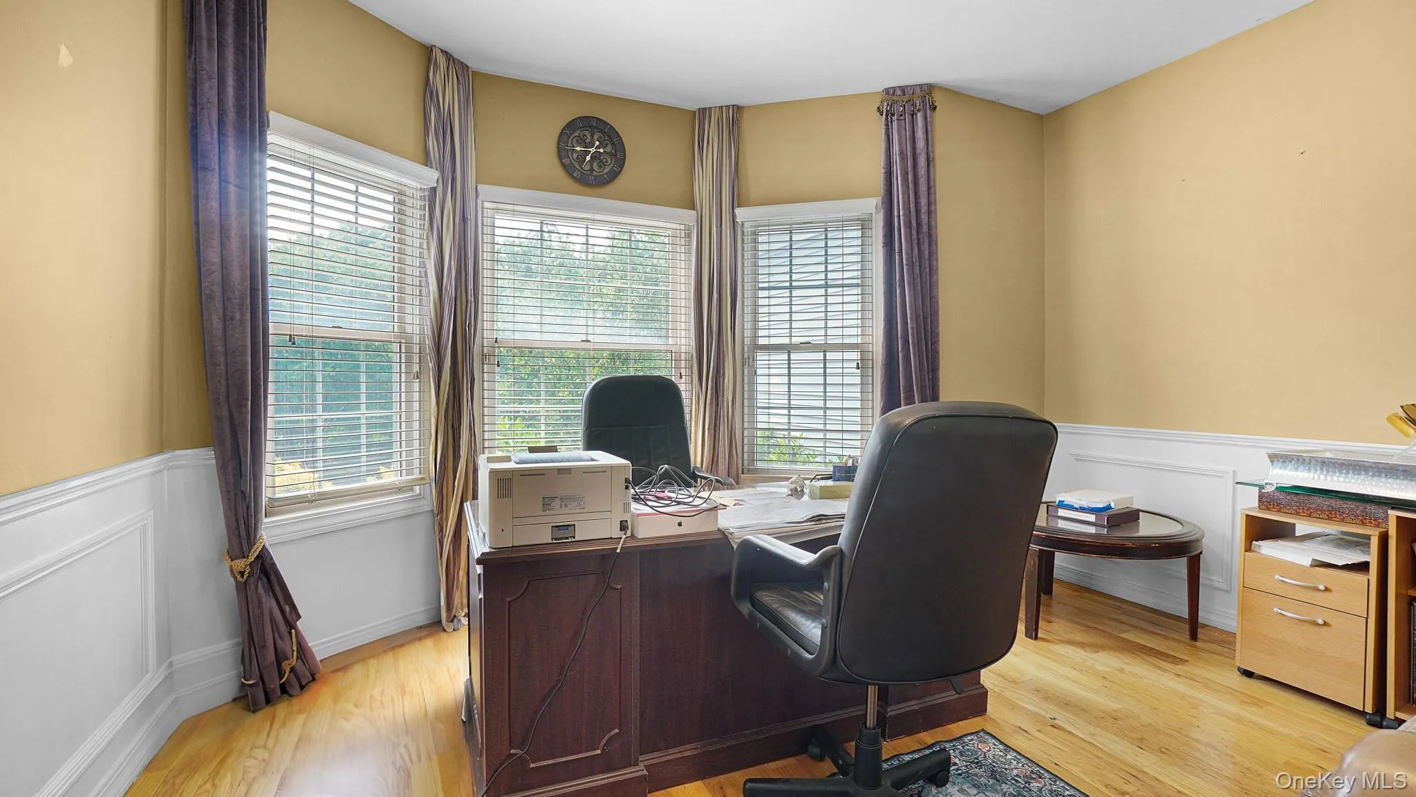 Home office featuring light wood-style floors and wainscoting Home office featuring light wood-style floors and wainscoting