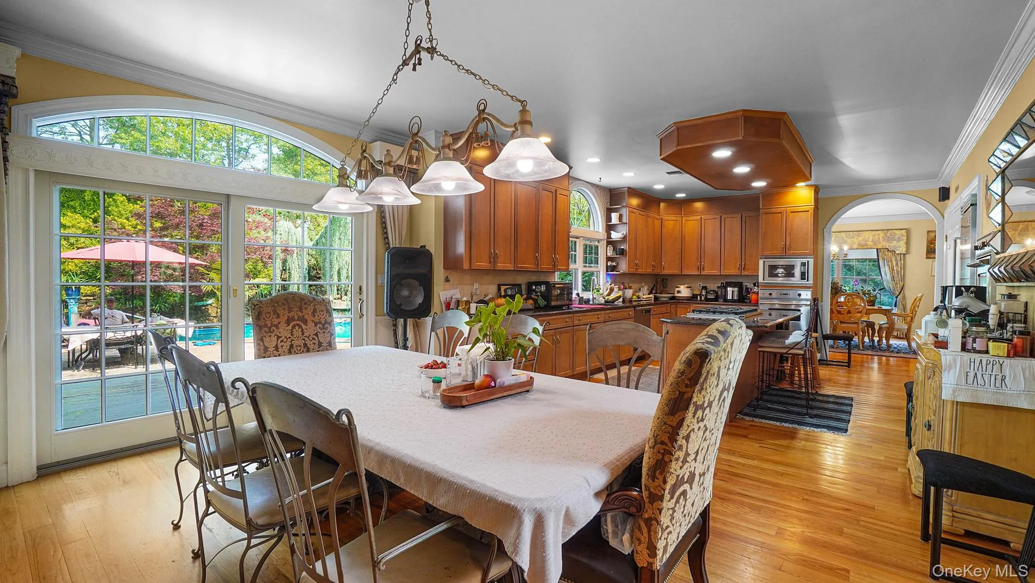 Dining room featuring crown molding, plenty of natural light, light wood-style flooring, arched walkways, and recessed lighting Dining room featuring crown molding, plenty of natural light, light wood-style flooring, arched walkways, and recessed lighting