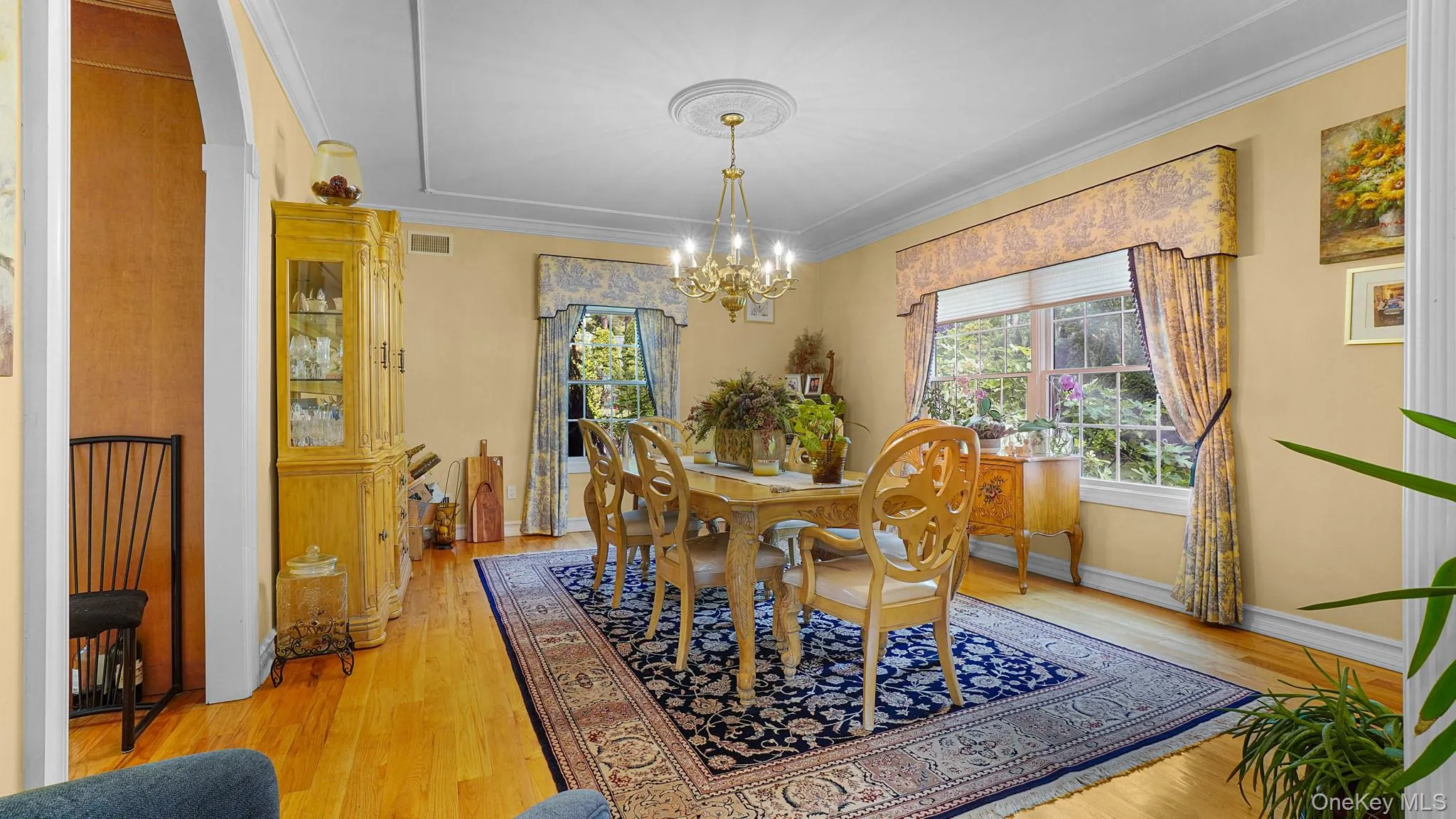 Dining space with a chandelier, plenty of natural light, ornamental molding, and light wood-type flooring Dining space with a chandelier, plenty of natural light, ornamental molding, and light wood-type flooring
