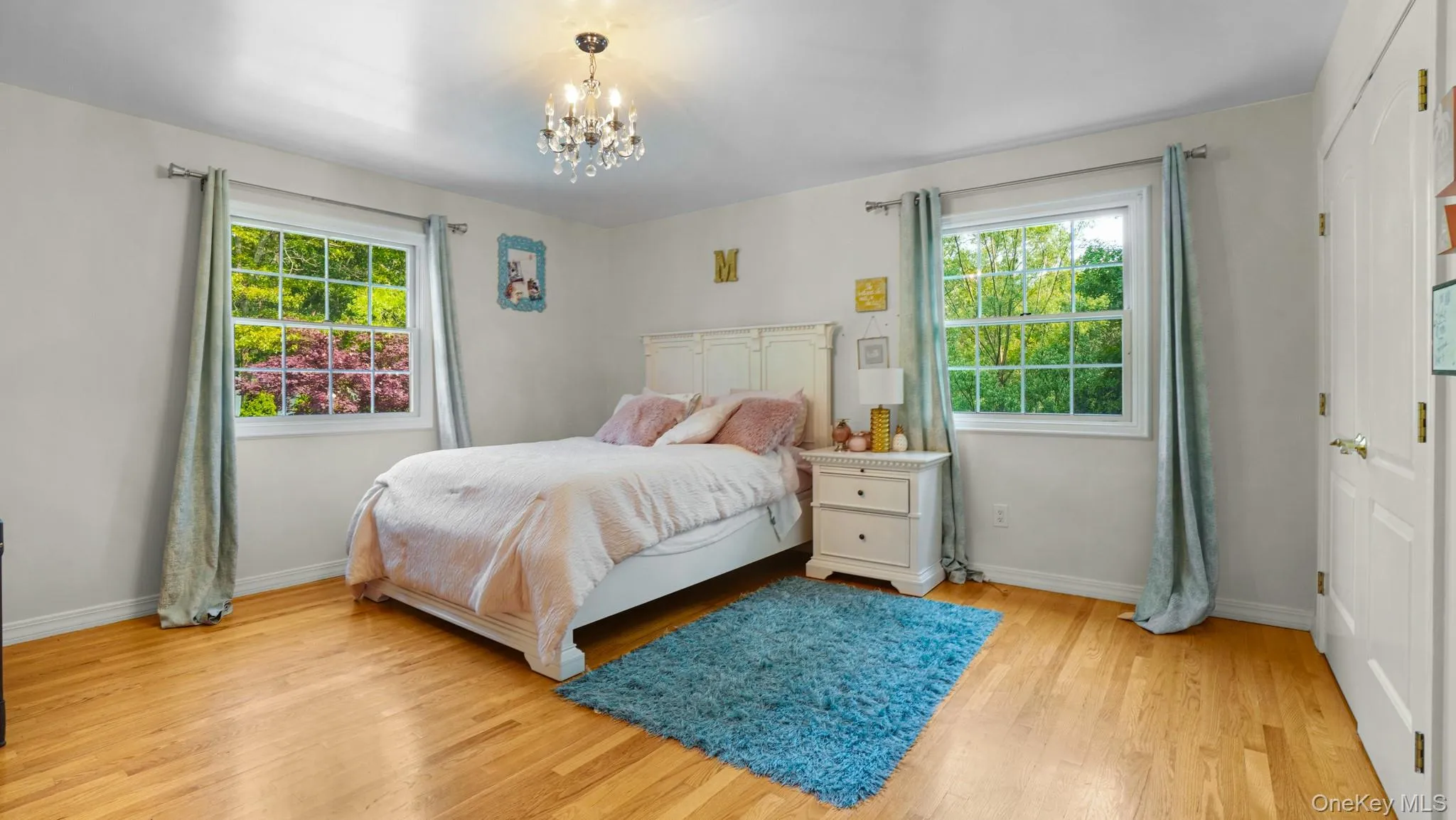 Bedroom with a chandelier and light wood finished floors Bedroom with a chandelier and light wood finished floors