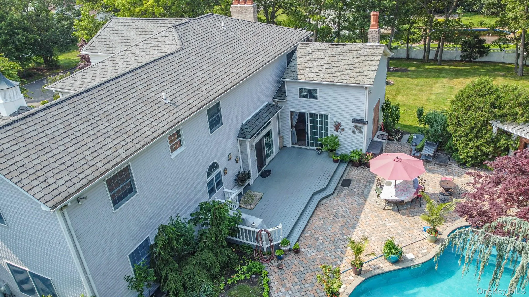 View of subject property with a pool and a tree filled landscape View of subject property with a pool and a tree filled landscape