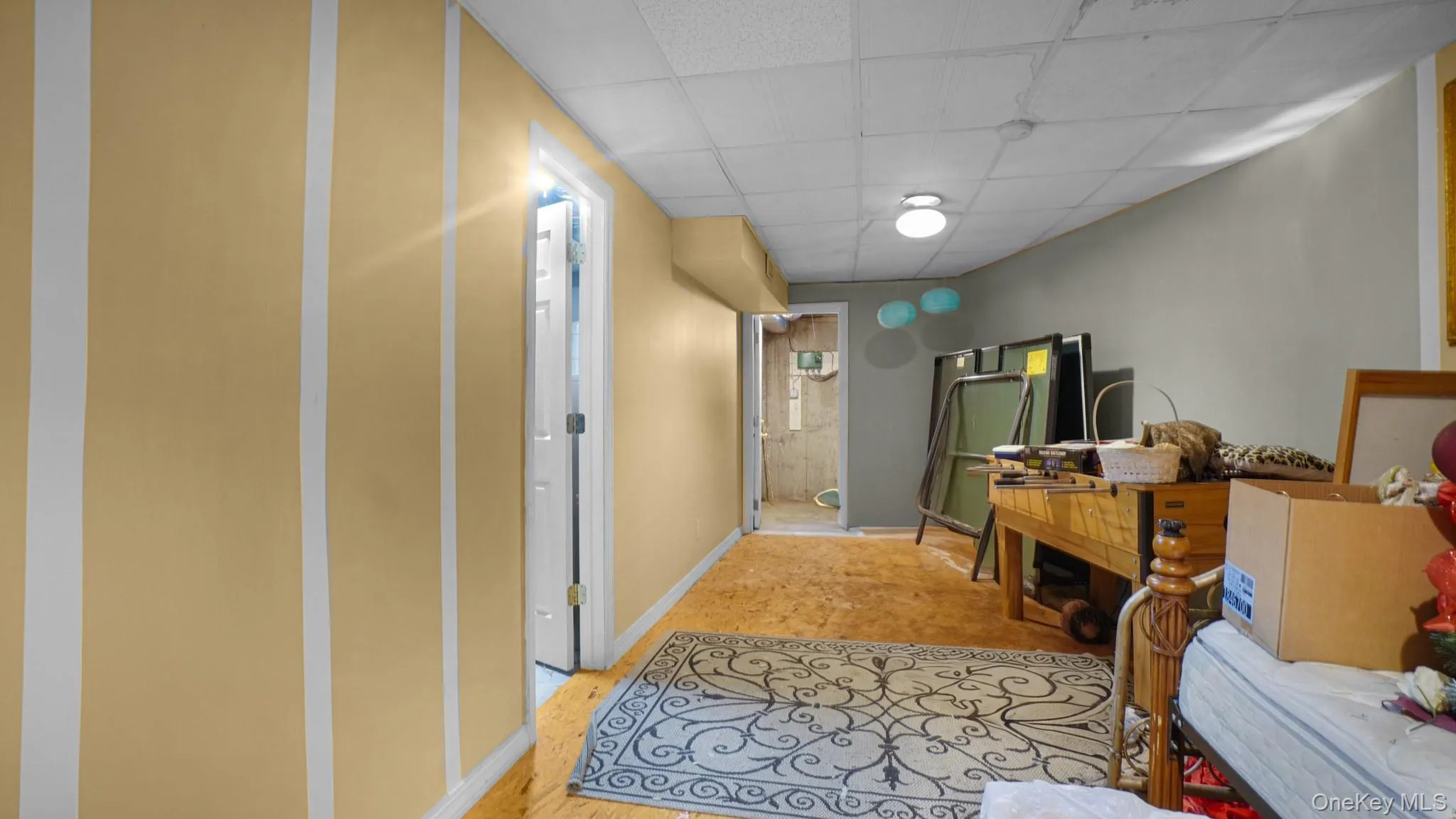 Corridor featuring baseboards and a drop ceiling Corridor featuring baseboards and a drop ceiling