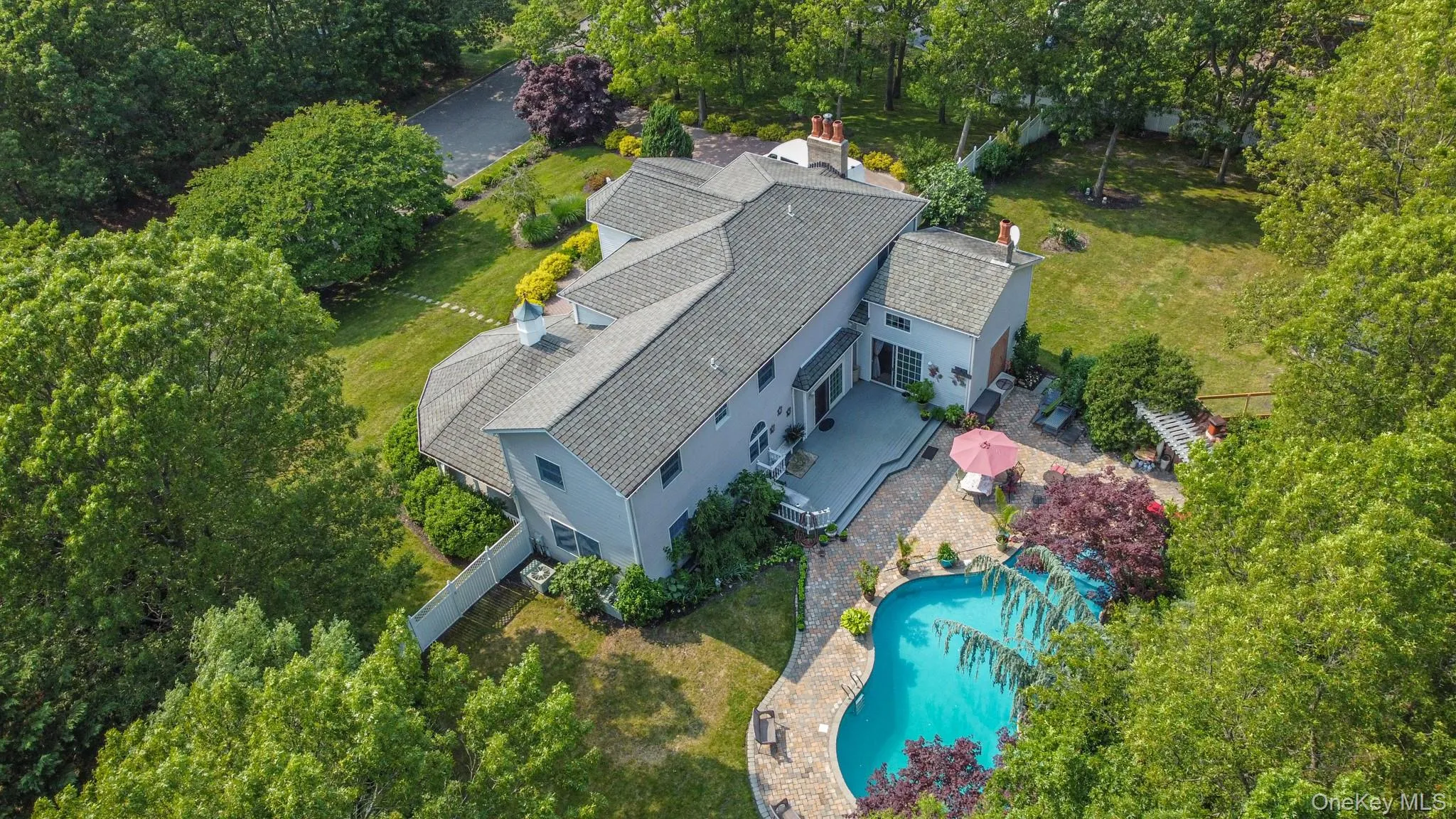 Aerial view of property and surrounding area featuring a pool and a tree filled landscape Aerial view of property and surrounding area featuring a pool and a tree filled landscape