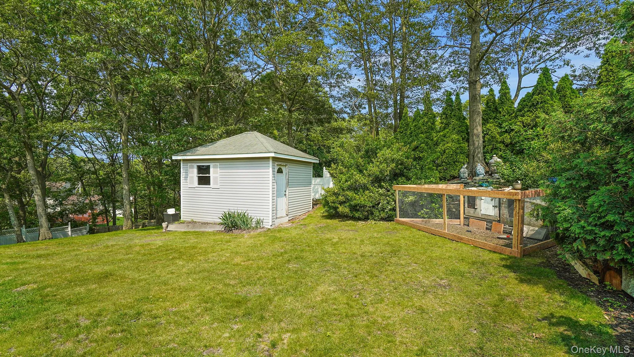 View of yard featuring a garden, a storage unit, and view of scattered trees View of yard featuring a garden, a storage unit, and view of scattered trees