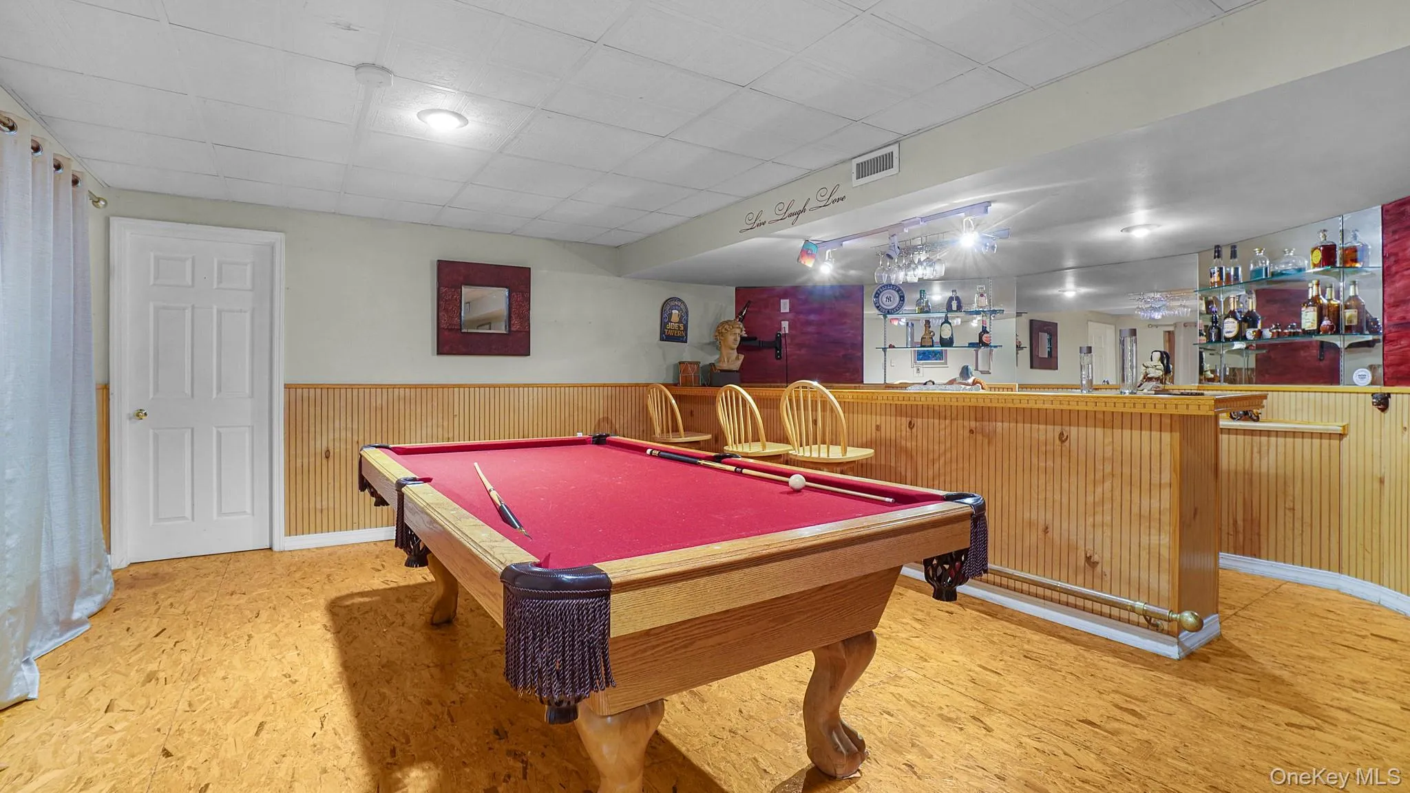 Rec room featuring bar area, wood finished floors, a wainscoted wall, billiards, and wooden walls Rec room featuring bar area, wood finished floors, a wainscoted wall, billiards, and wooden walls