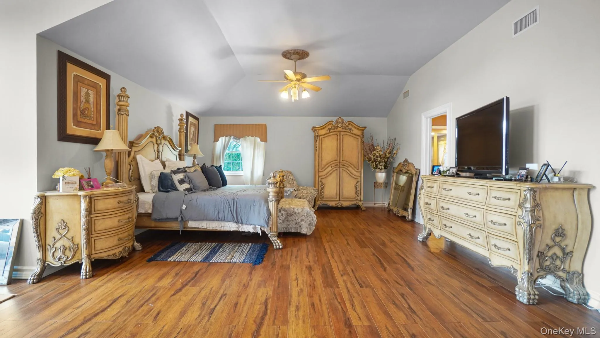 Bedroom with wood finished floors, lofted ceiling, and ceiling fan Bedroom with wood finished floors, lofted ceiling, and ceiling fan