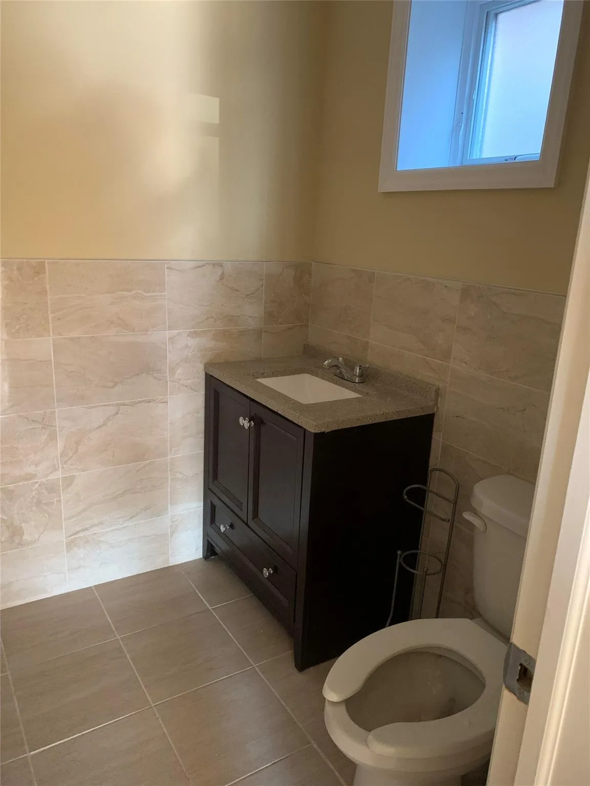 Bathroom with tile walls, vanity, tile patterned floors, and wainscoting Bathroom with tile walls, vanity, tile patterned floors, and wainscoting