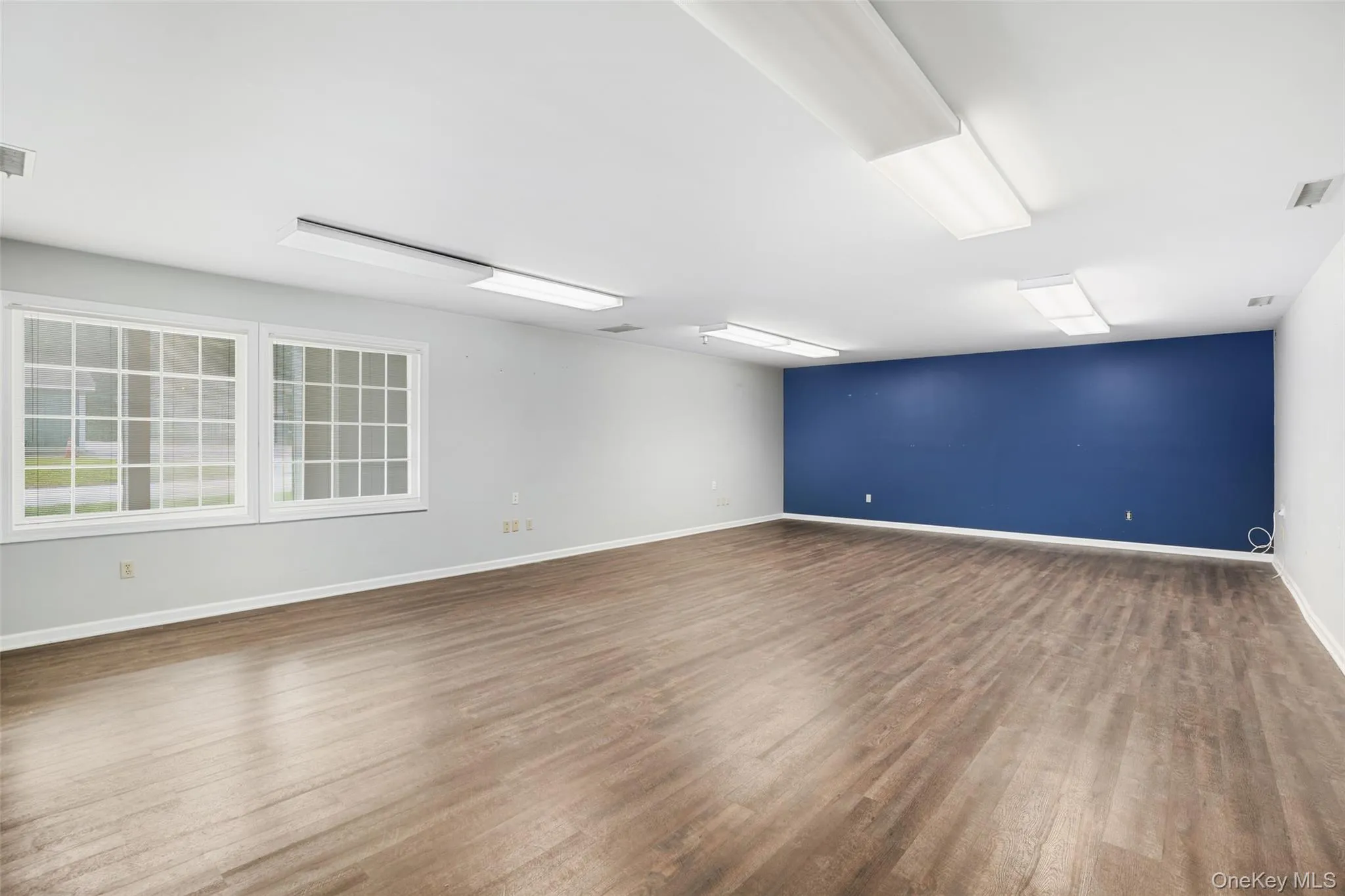 Empty room with dark wood-style floors and baseboards Empty room with dark wood-style floors and baseboards