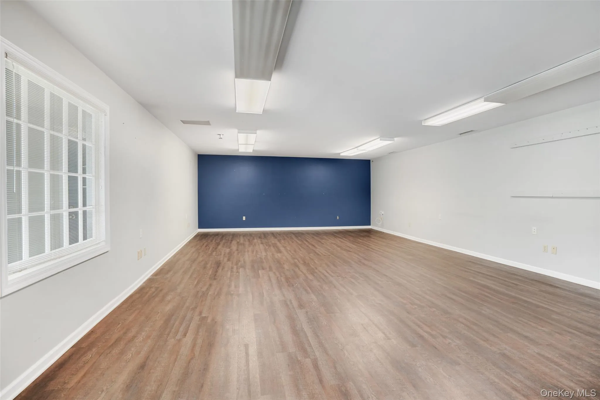 Empty room featuring wood finished floors and baseboards Empty room featuring wood finished floors and baseboards