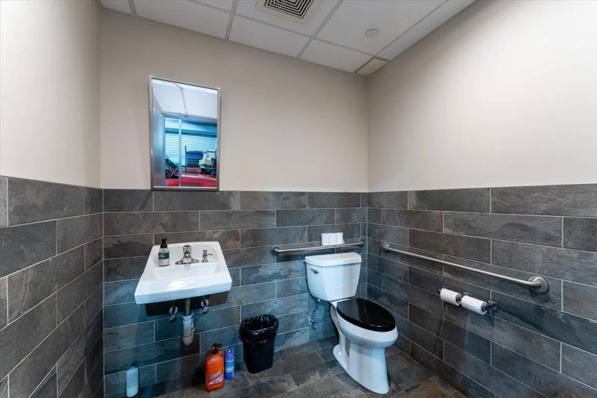 Bathroom featuring tile walls, a paneled ceiling, wainscoting, and tile patterned flooring Bathroom featuring tile walls, a paneled ceiling, wainscoting, and tile patterned flooring