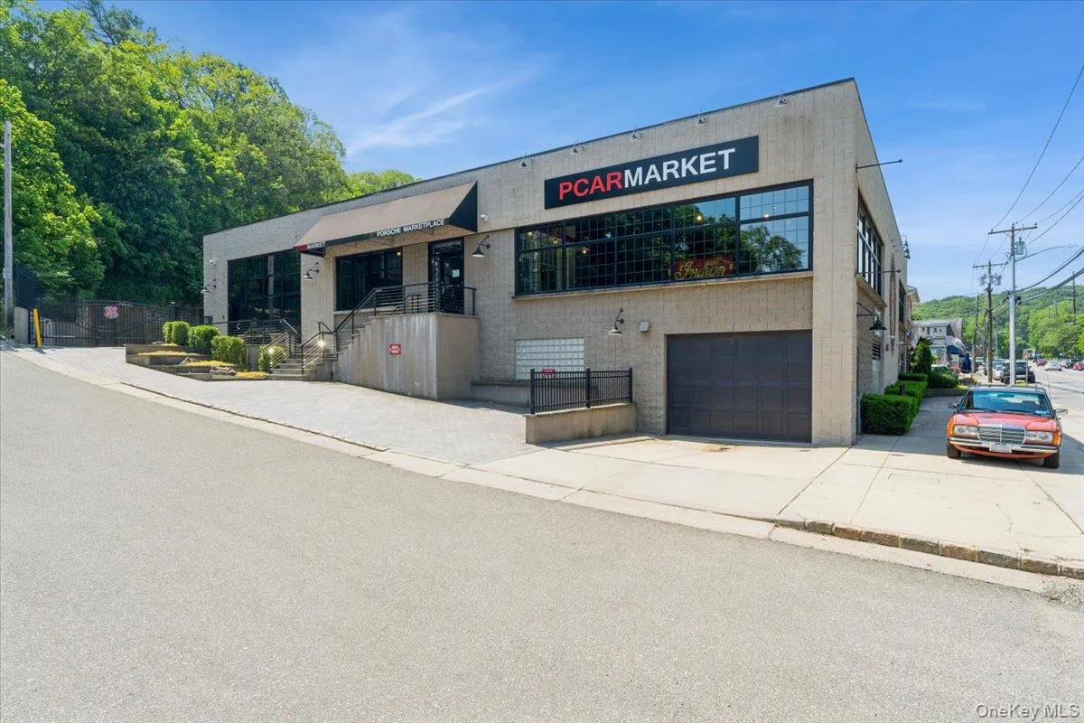View of building exterior featuring a garage and concrete driveway View of building exterior featuring a garage and concrete driveway