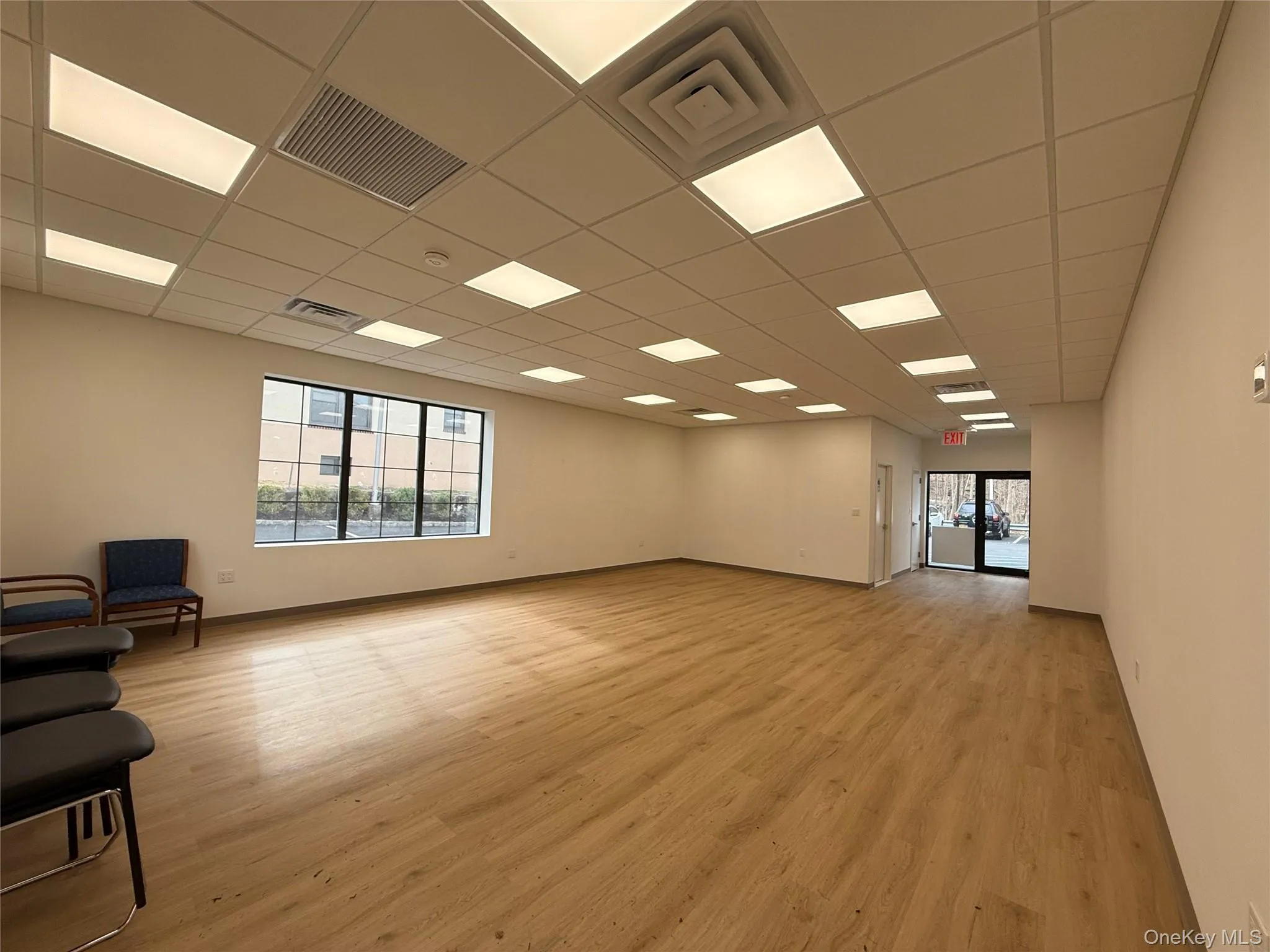 Empty room with light wood-style floors and a paneled ceiling Empty room with light wood-style floors and a paneled ceiling