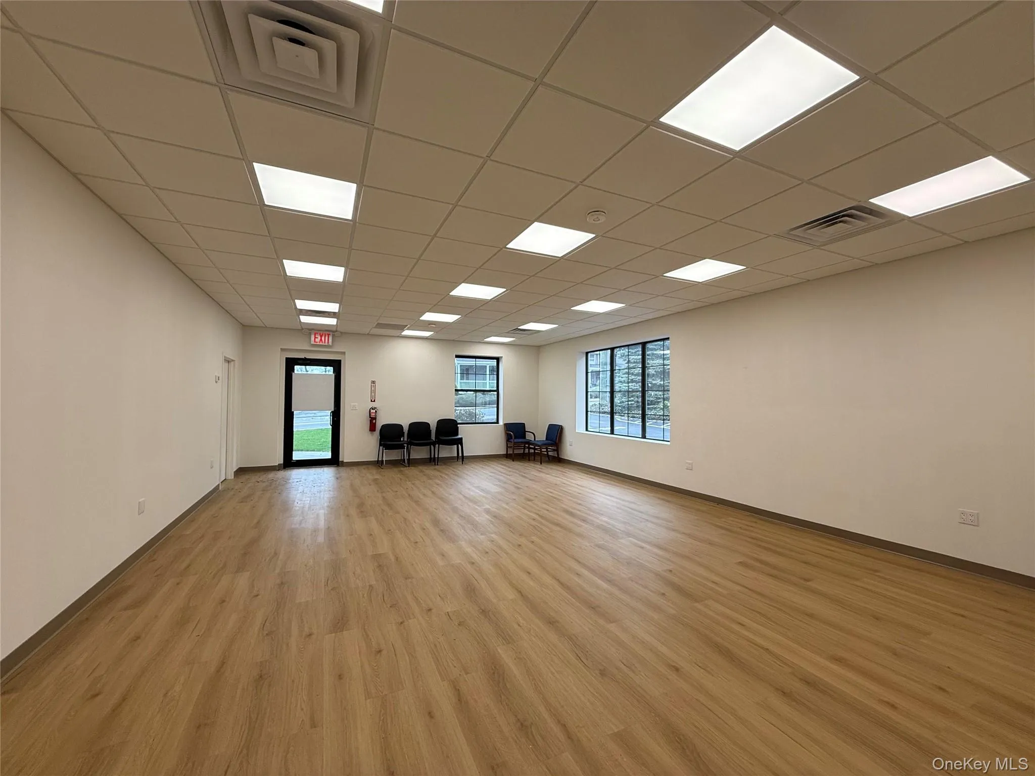 Empty room featuring light wood-style flooring and a paneled ceiling Empty room featuring light wood-style flooring and a paneled ceiling
